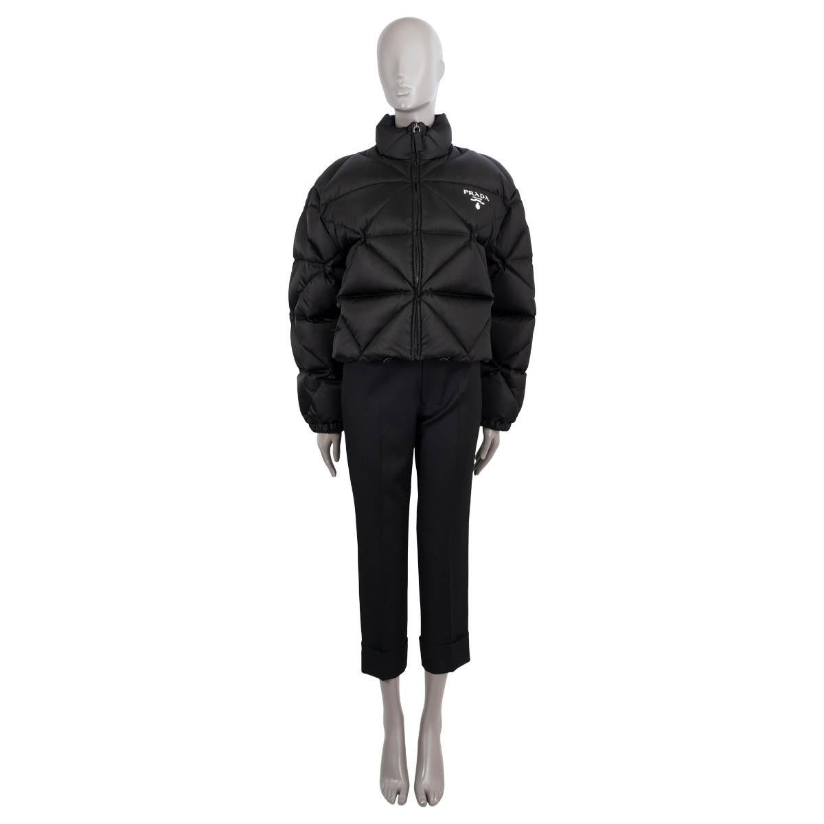 100% authentic Prada cropped down jacket in black re-nylon gaberdine (100%). Features triangle quilting, logo print, stand-up collar, elastic cuffs and drawstring hem. Closes with a zipper on the front and is lined in polyamide (100%). Filling is