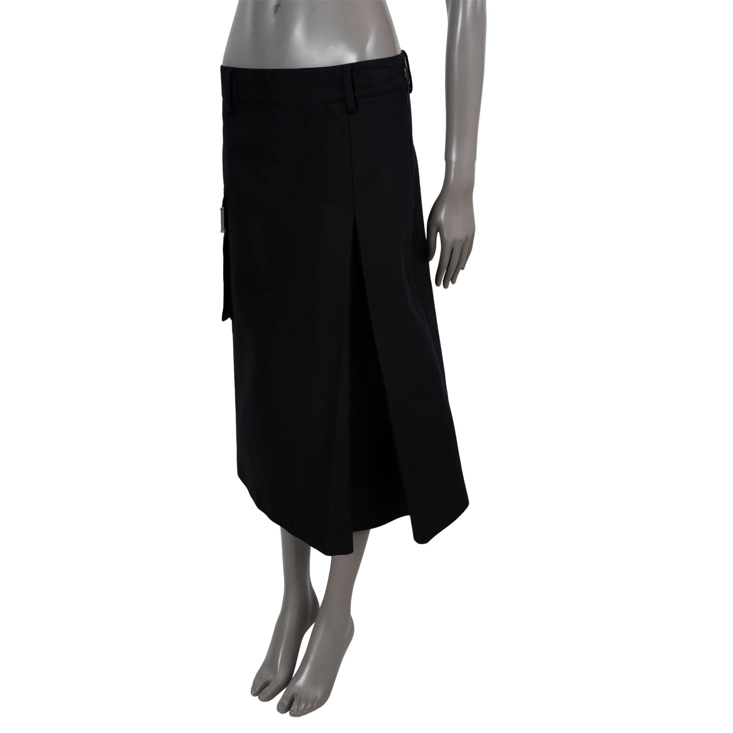 100% authentic Prada A-line midi skirt in black technical canvas (polyamide 51% and cotton 49%). Features a cargo flap pocket on the side with triangle patch, a side front-pleat and slit in the back. Closes with a concealed zipper on the side and is