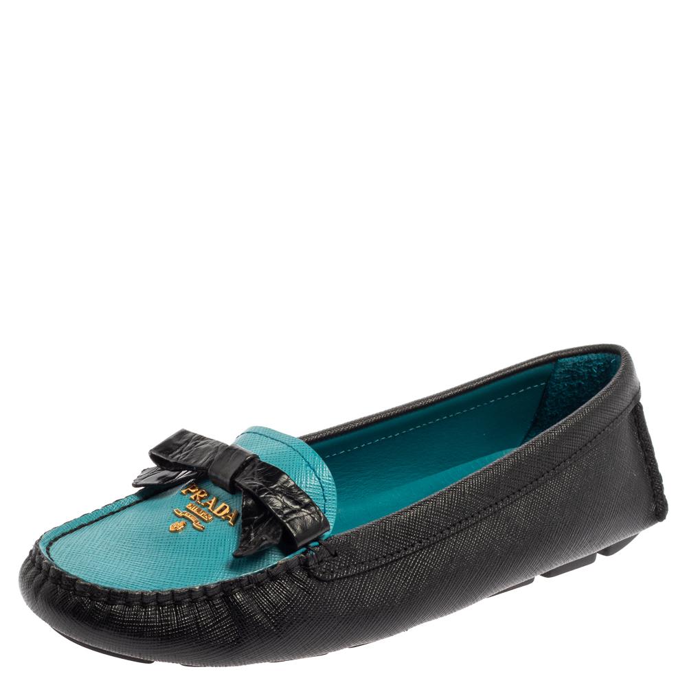 Sleek and luxe, these loafers by Prada will enhance your ensembles by giving them an edge. Meticulously crafted from blue and black Saffiano leather, they carry fine stitching and logo and bow details on the vamps. The pair is complete with