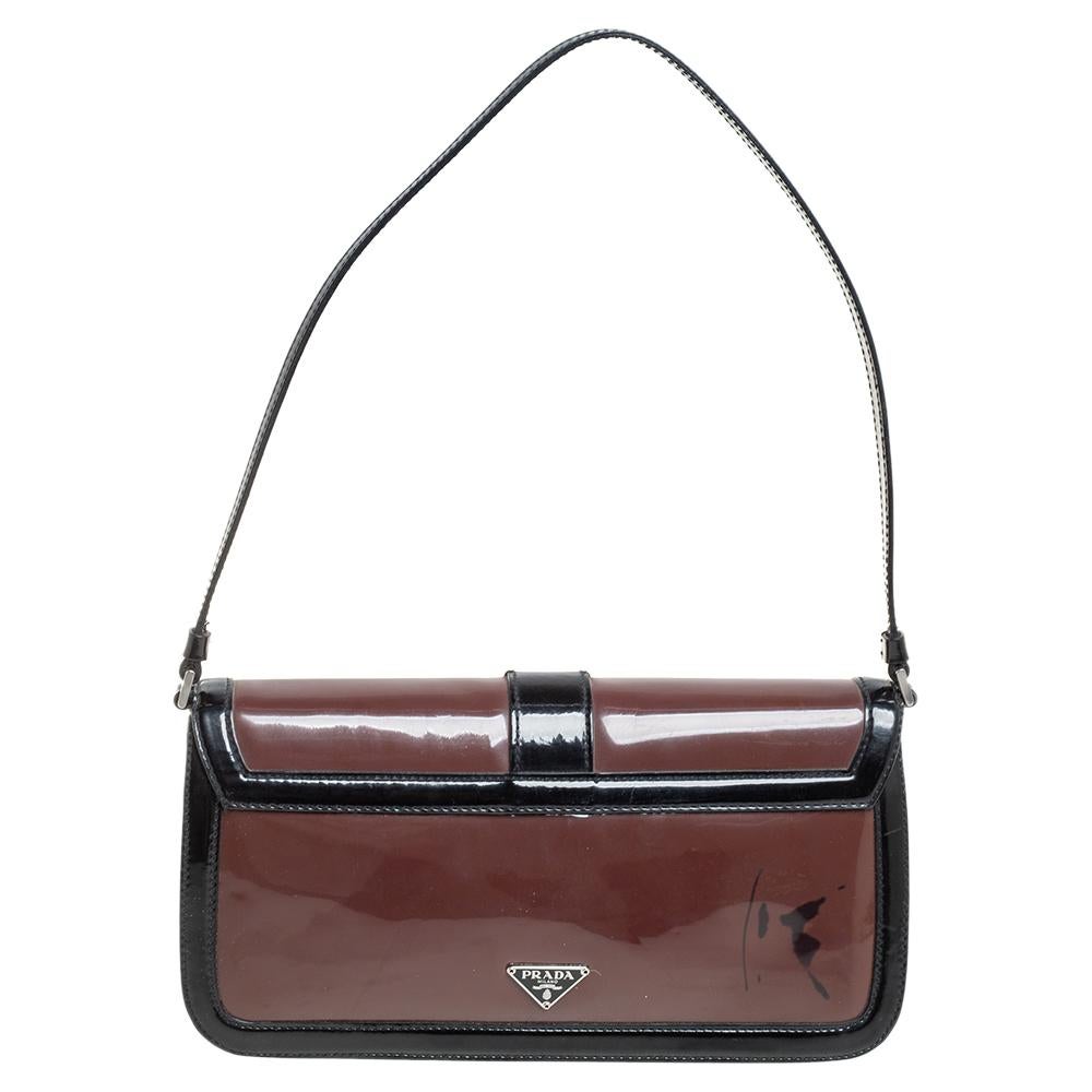 This chic and functional Prada baguette would go perfectly well with all your events. The inside fabric is sewn to magnificence to give flexibility in handling. Made by the best, this patent leather handbag features a flap.


