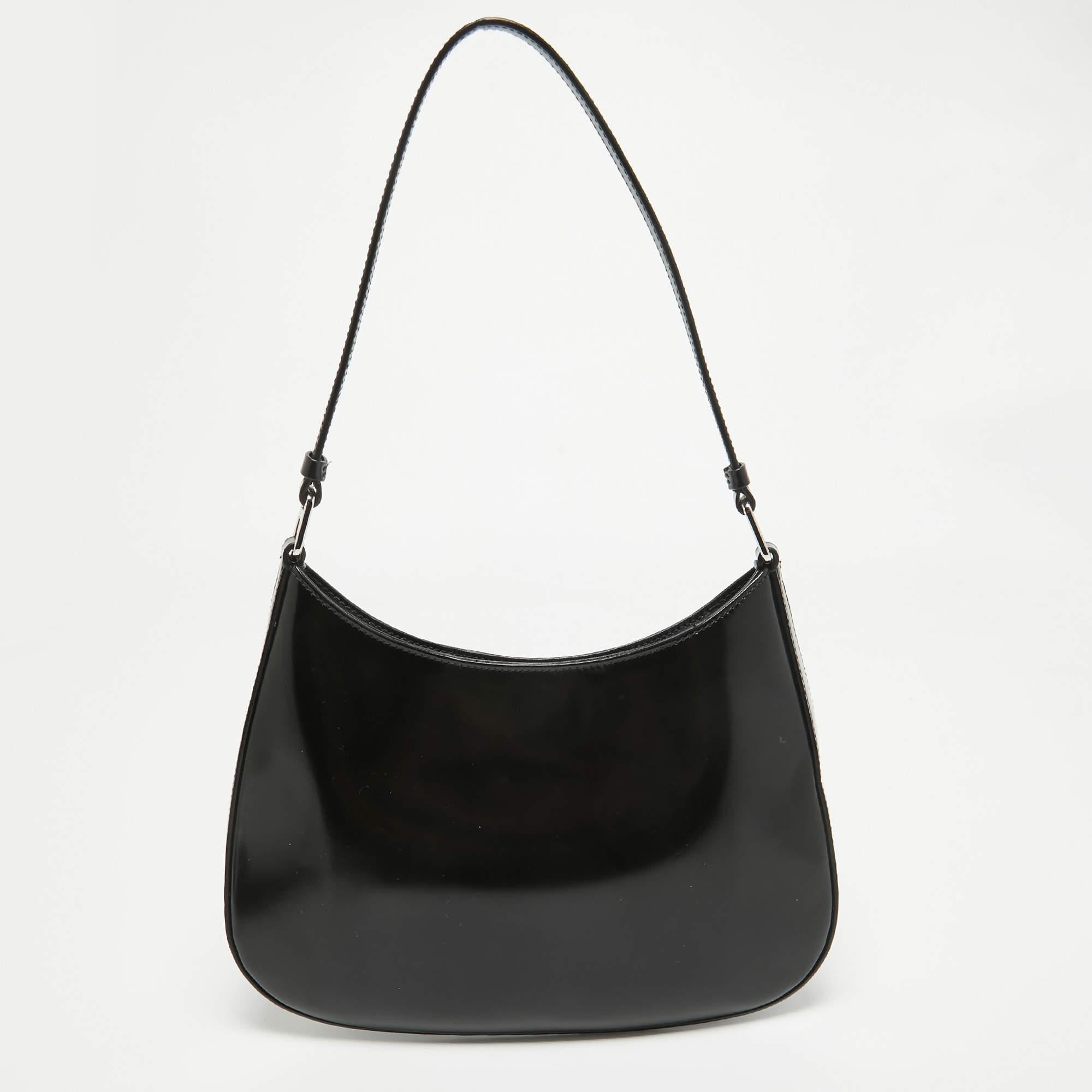 Confectionné avec précision, le sac à bandoulière Cleo de Prada affiche une allure intemporelle. Son cuir souple, méticuleusement brossé à la perfection, affiche un charme à la fois élégant et discret. Avec son intérieur spacieux et sa bandoulière