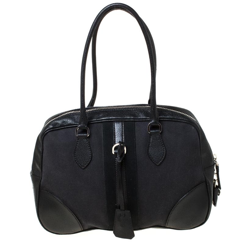 This Bowler bag from Prada is simple in design but highly functional. Crafted from black canvas and leather trims, the bag features two handles, gold-tone hardware and a top zipper leading to a nylon interior for your necessities. The bag will be a