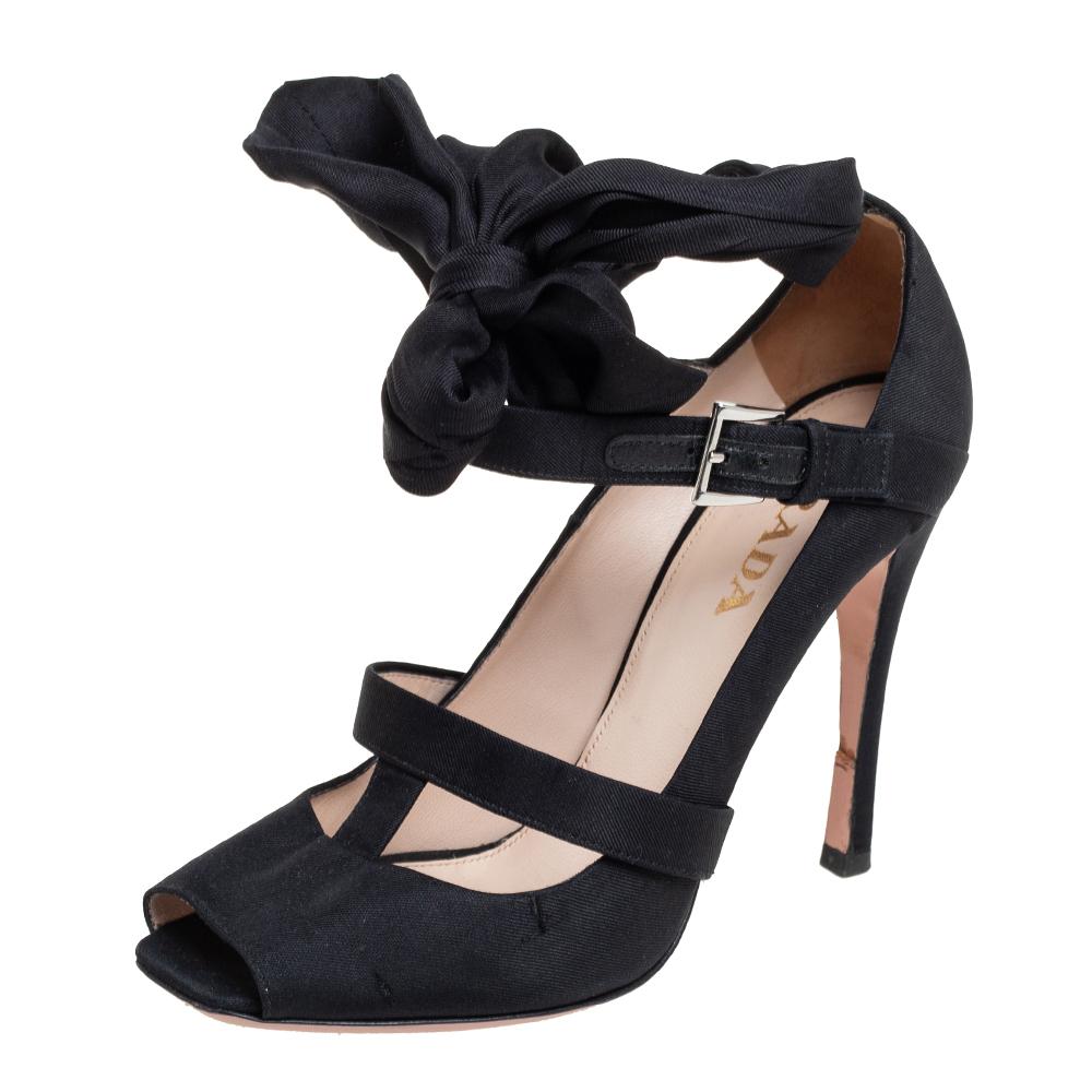 These sandals by Prada are chic and perfect for a host of occasions. They are crafted from canvas and come in a classic shade of black. They have strappy uppers, knot detailing, 11 cm heels and silver-tone hardware.

