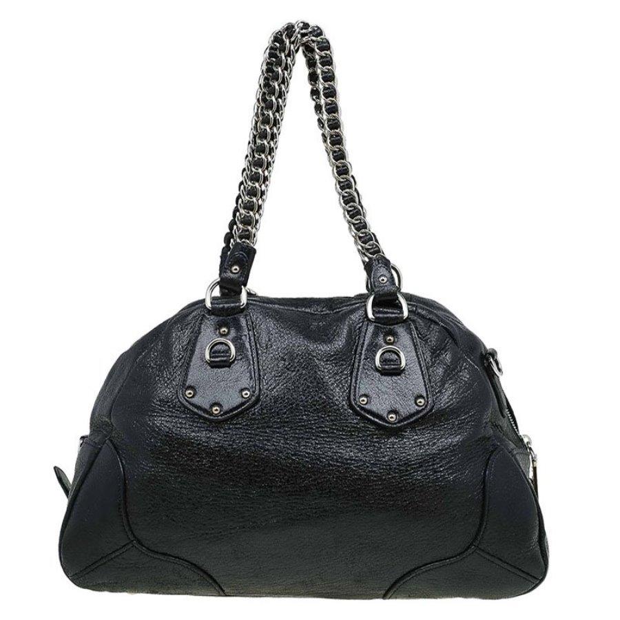 With a distinctive style of its own, this Prada bag is crafted from black Cervo lux leather. It features silver tone hardware with a double leather-metal link chain strap and also, a detachable leather strap and a top zip closure. The triangular