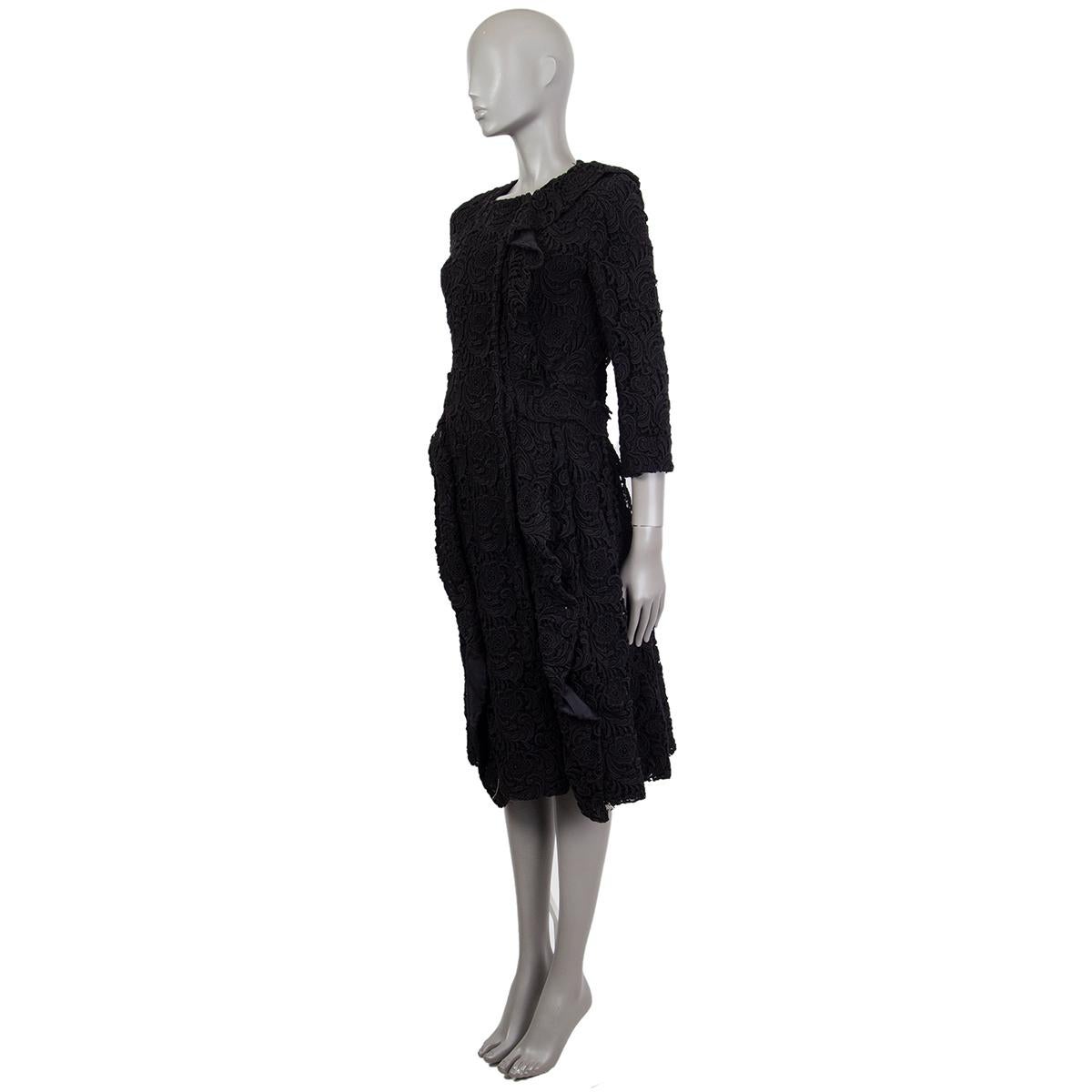 100% authentic Prada front ruffle embroidered-lace coat in black cotton (90%) and polyester (10%) with 3/4 sleeves and waist belt in the back. Closes with concealed snap-buttons on the front. Lined. Has been worn and is in excellent