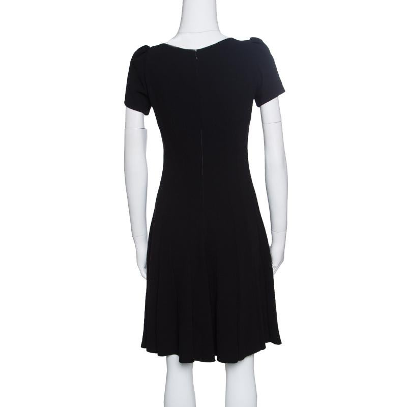 Prada never fails to create pieces that are a perfect blend of classic and modern and this black dress is just another fabulous creation. It is made of a polyester blend and features an elegant silhouette. It flaunts a round neckline, front btton
