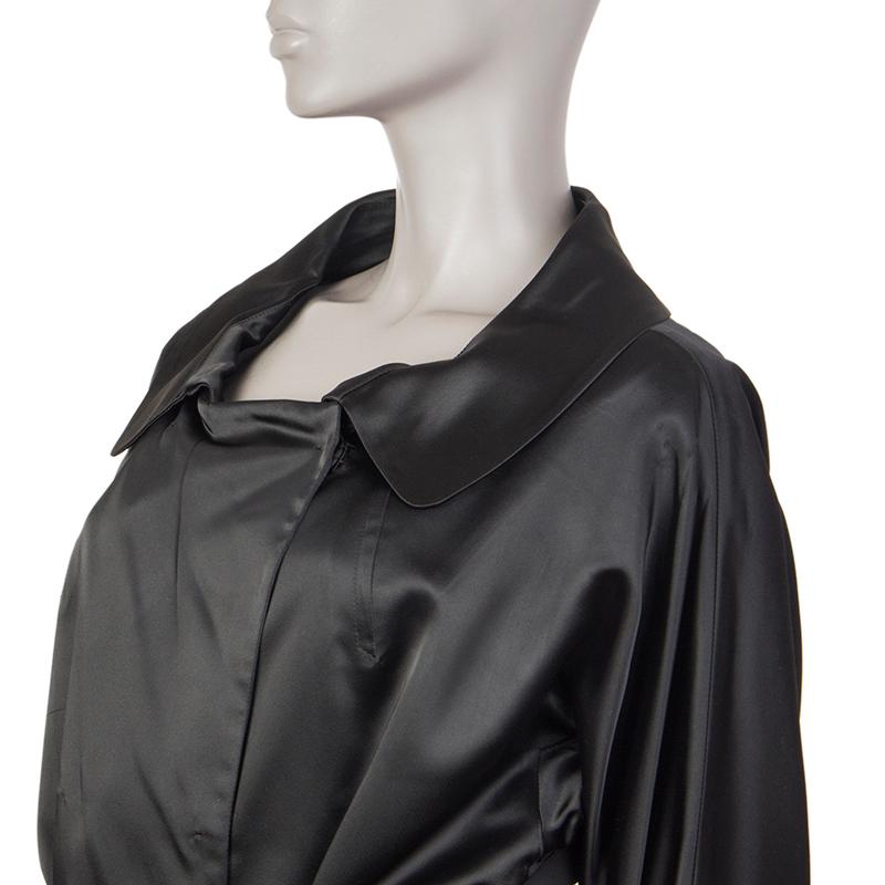 100% authentic Prada double-breasted satin coat in black acetate (100%) with rounded collar, two slit pockets on the front, sinched cuffs, a slit on the back, and belt loops. Closes with concealed snaps and comes with a belt. Unlined. Comes with