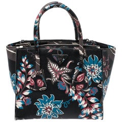 Prada Tasche aus schwarzem Saffiano-Leder mit Blumenmuster und doppeltem Reißverschluss.