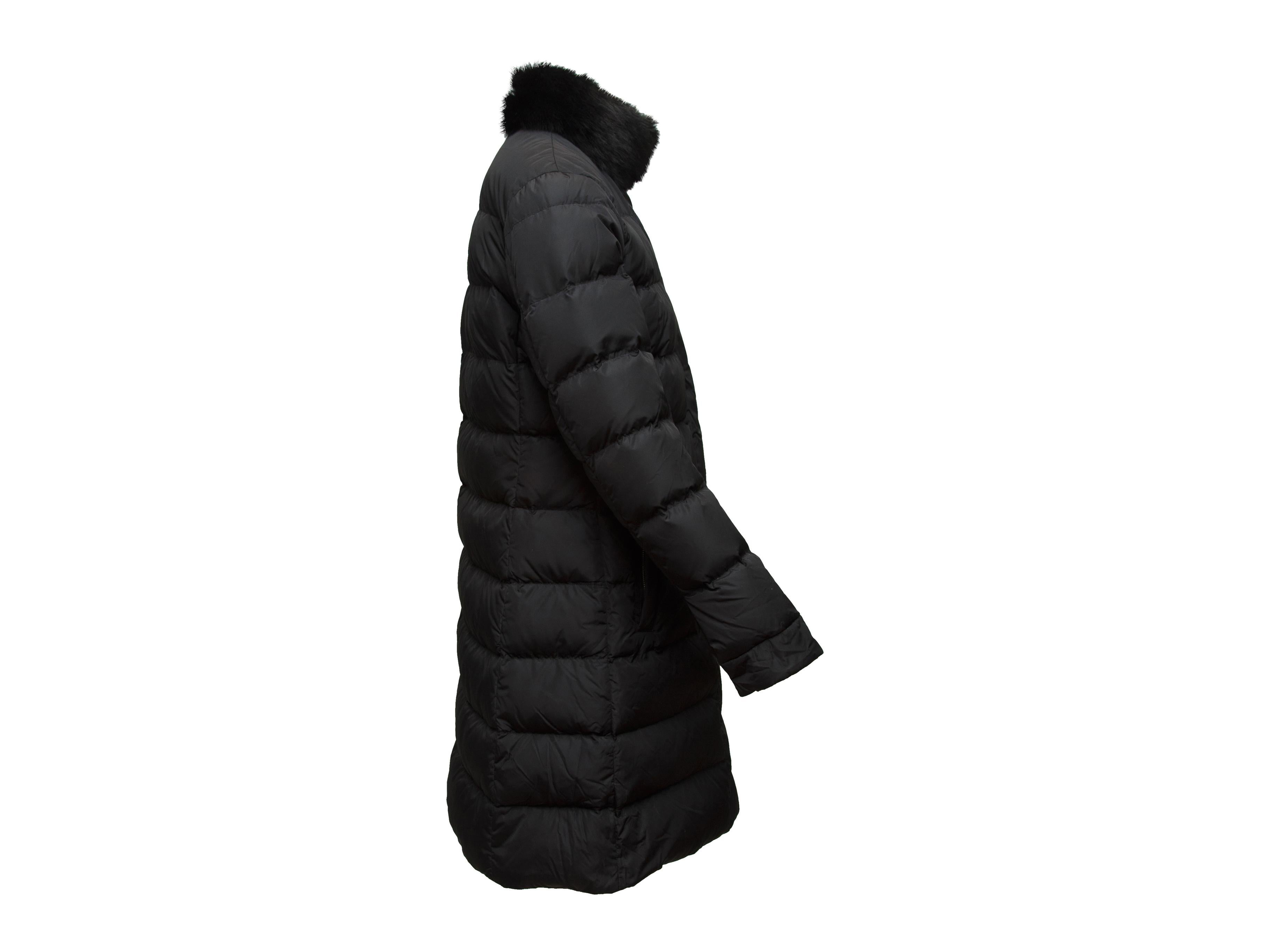 Product details: Black mid-length puffer coat by Prada. Fur trim at high collar. Dual pockets at hips. Zip closure at front. Designer size 44. 35