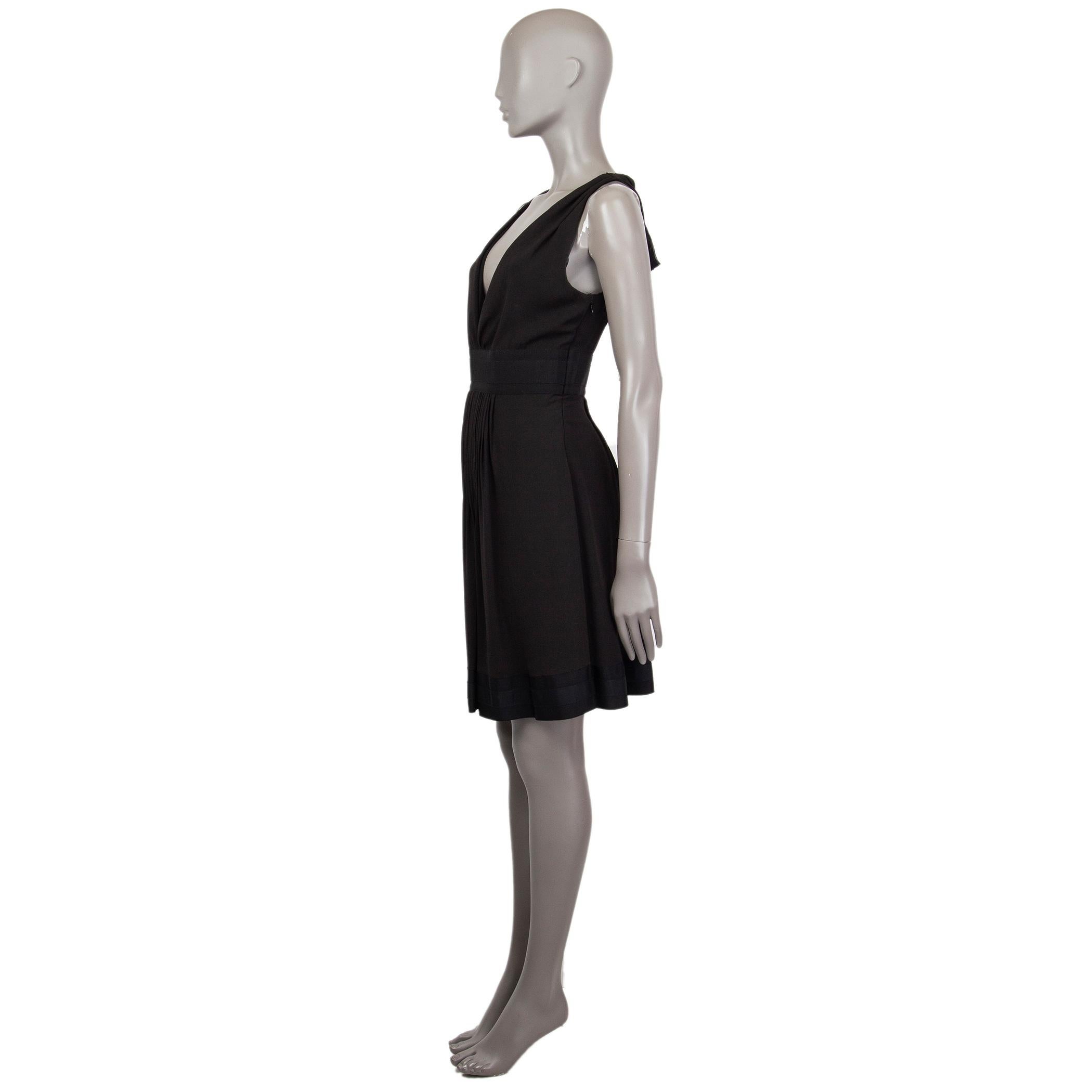 Prada gathered-front black dress in black triacetate (60%) and polyester (40%) with a v-neck. Has trimming around the waist and bottom in black silk (100%). Closes on the side with concealed zipper and ties around the back of the neck. Unlined. Has