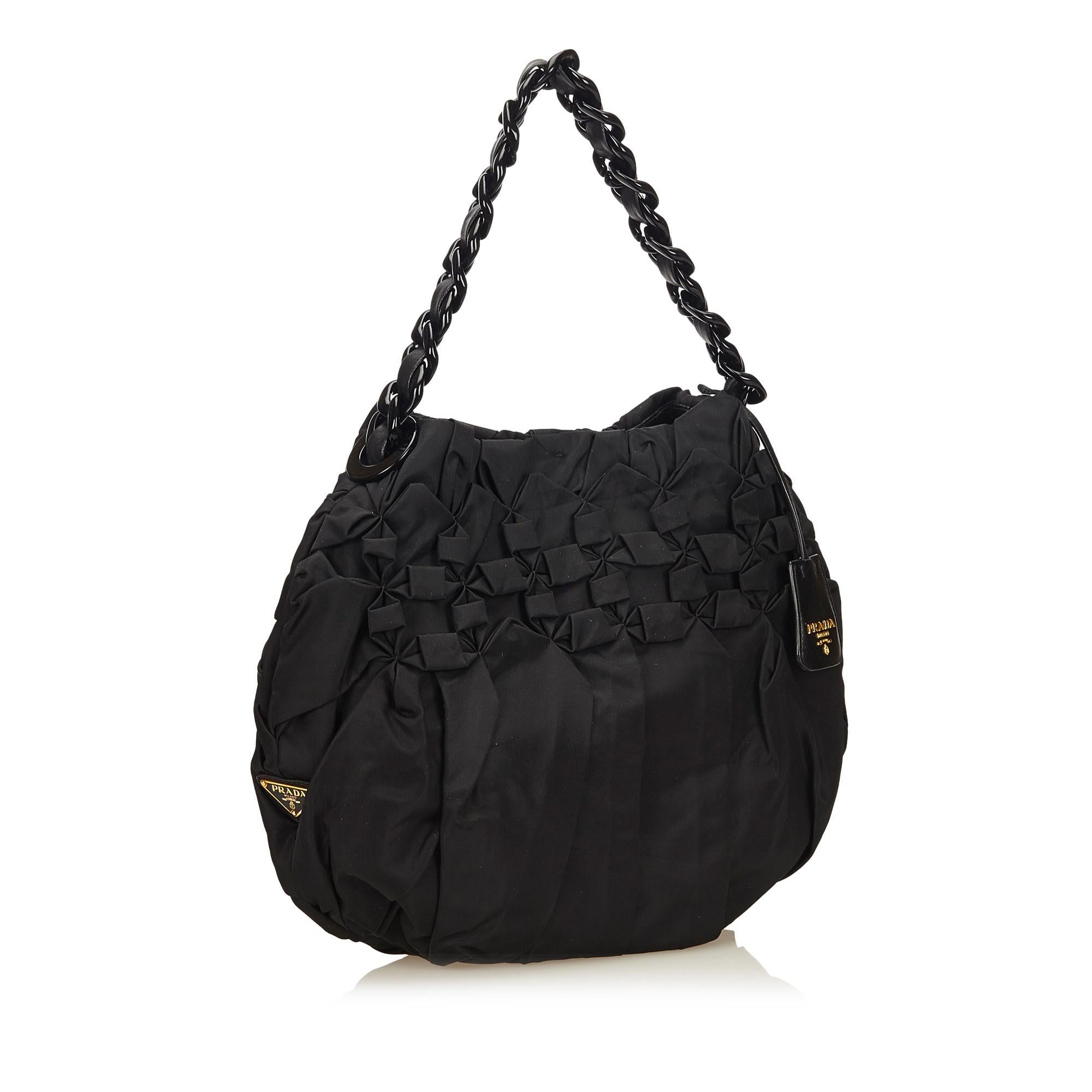 This shoulder bag features a nylon body, leather chain strap, open top with magnetic closure, and interior zip and slip pockets. It carries as AB condition rating.

Inclusions: 
This item does not come with inclusions.

Dimensions:
Length: 29.00