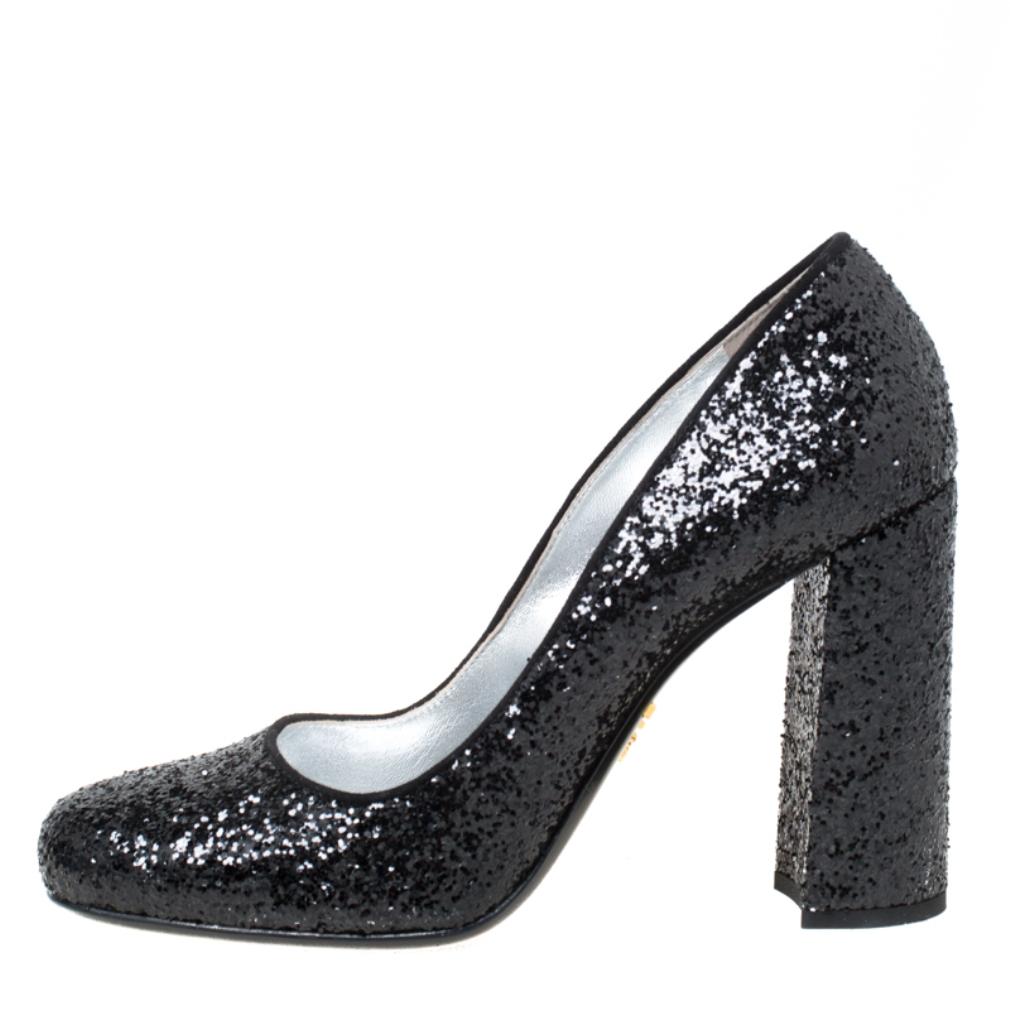 Fashion and comfort come together with these pumps from Prada! Covered in black glitter and shaped into round toes and 10 cm block heels, these pumps will be a winner with all your well-tailored outfits.

Includes: Original Box

