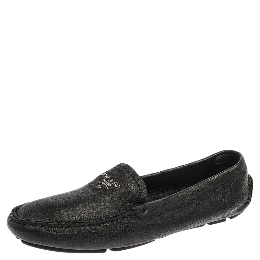 Sleek and stylish, these black loafers by Prada will enhance your outfits by giving them a touch of luxury. Meticulously crafted from grained leather, they carry neat stitches and silver-tone logos on the vamps. The pair is complete with durable