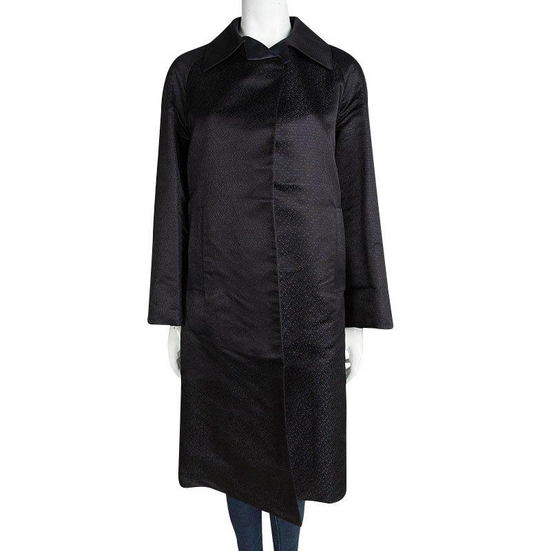 Elevate your coat obsession with this classic overcoat from Prada. This black coat is made of 100% jacquard silk and features mini leaf patterns all over it. It flaunts long sleeves, wide collars and a simple structured silhouette along with a long