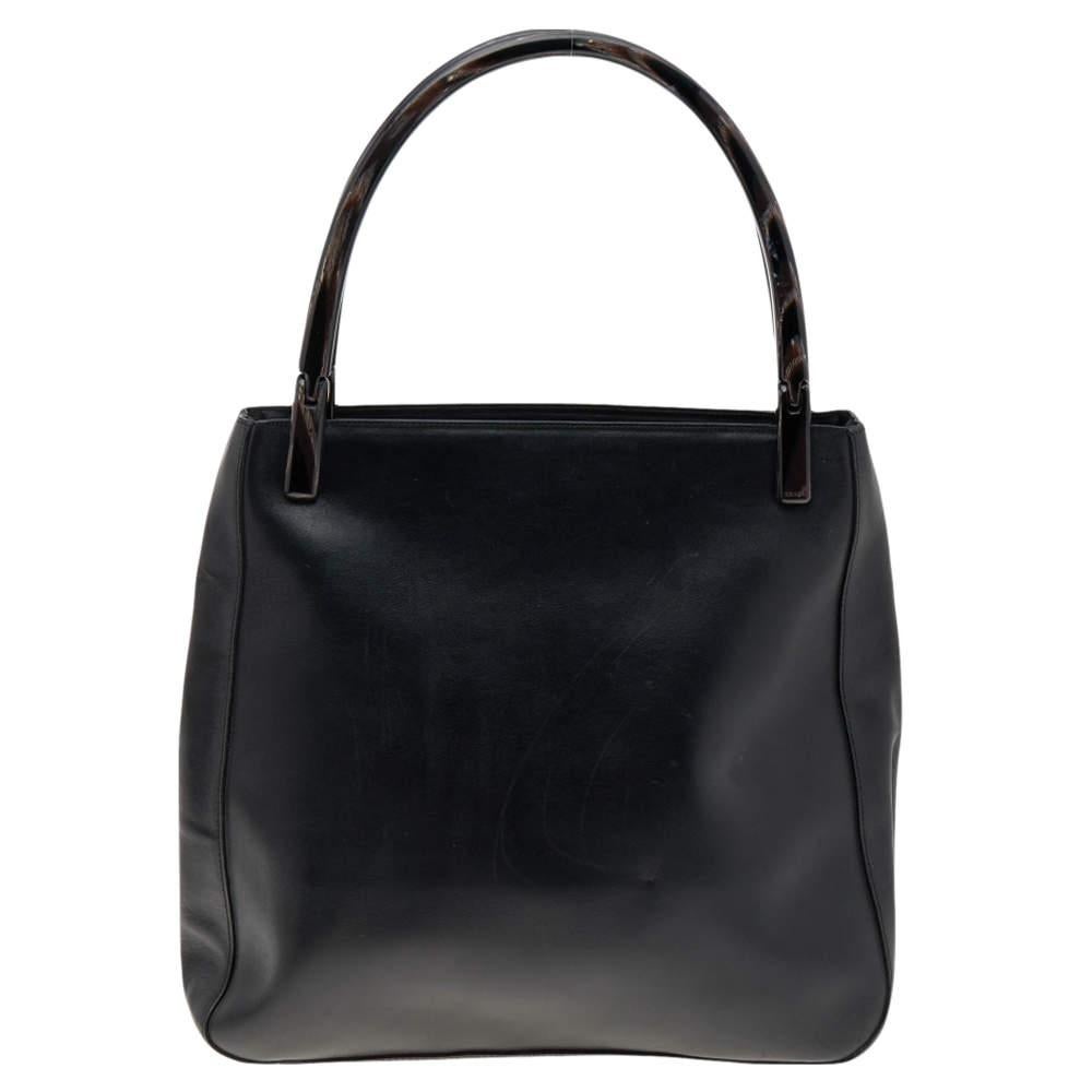 This tote from Prada is a fine blend of function and style. It features a leather construction, acrylic top handles, and silver-tone hardware. It is equipped with a nylon interior that can easily hold your daily essentials.

