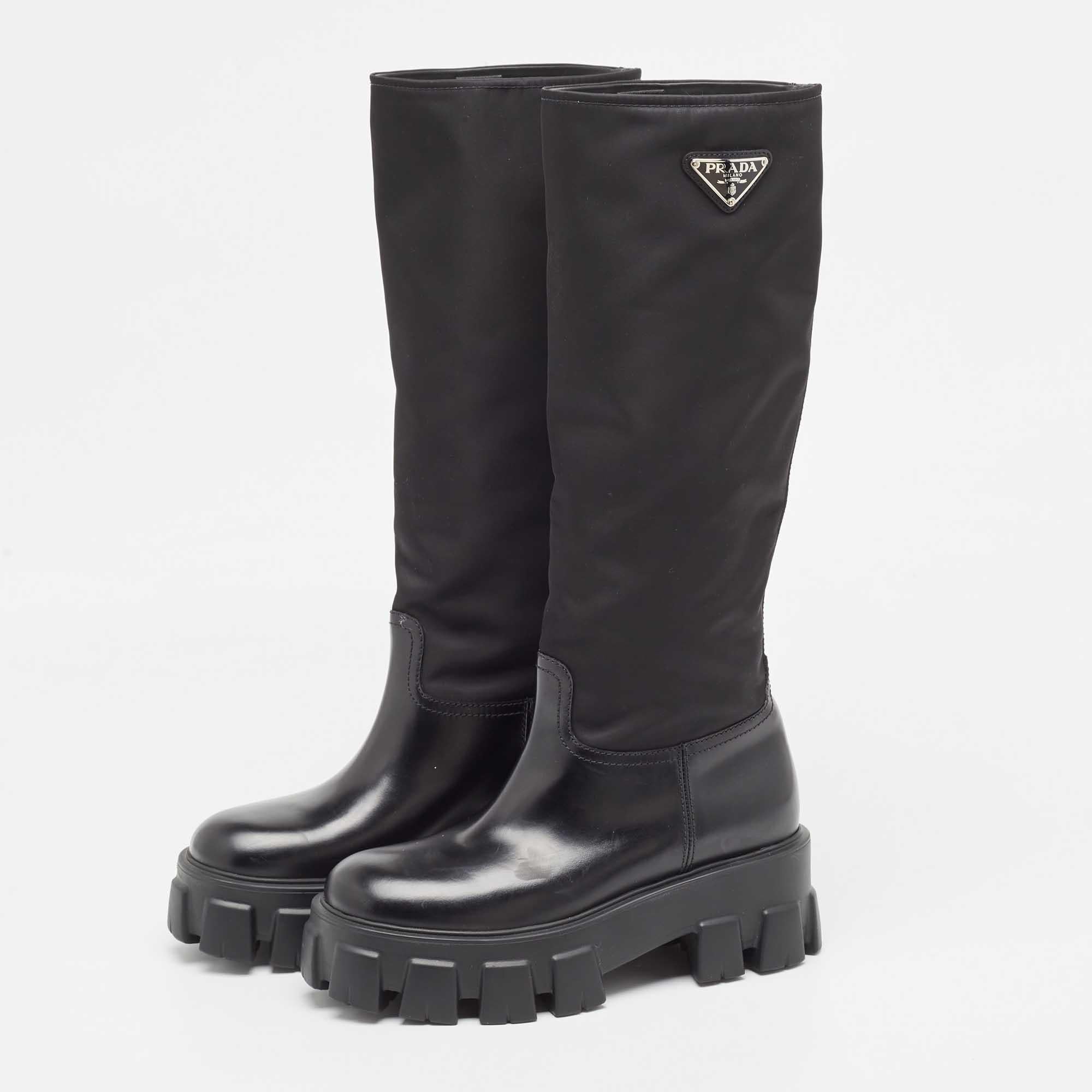 Nail a confident look with these Prada Monolith boots! They're made of leather as well as nylon and have the iconic triangle logo on the sides.

