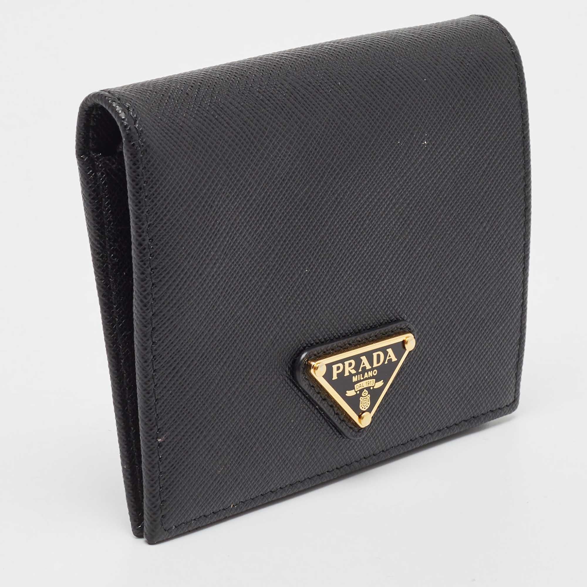 This Prada bifold wallet is the most classy way to organize your essentials. The black leather creation is detailed with the brand logo at the front and features an interior equipped with a flap coin pocket, multiple card slots, and slip