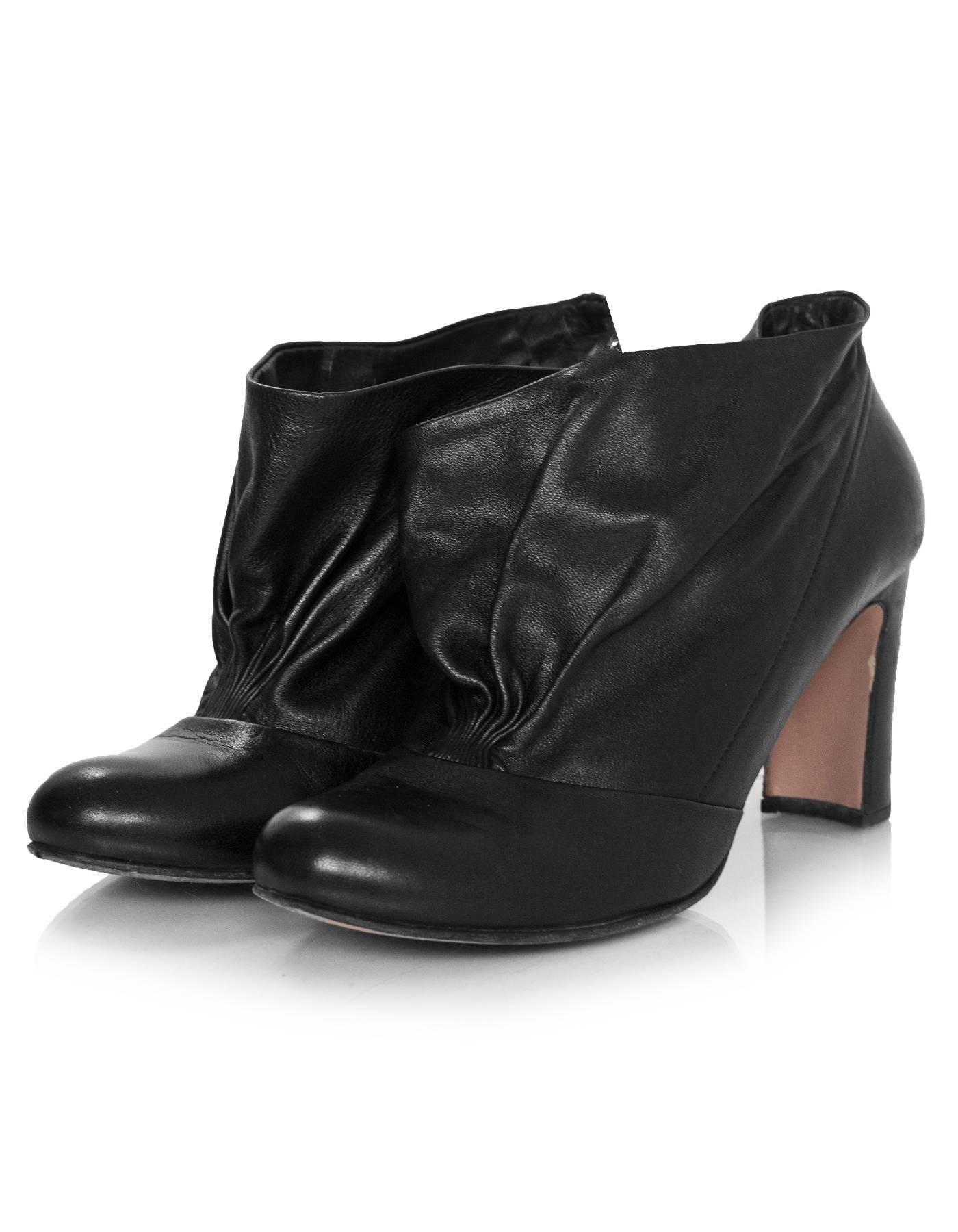 Prada Black Leather Booties Sz 37.5

Made In: Italy
Color: Black
Materials: Leather
Closure/Opening: Slip on
Sole Stamp: Prada 37.5 Made in Italy
Overall Condition: Excellent pre-owned condition with the exception of some wear at outsoles, marks at