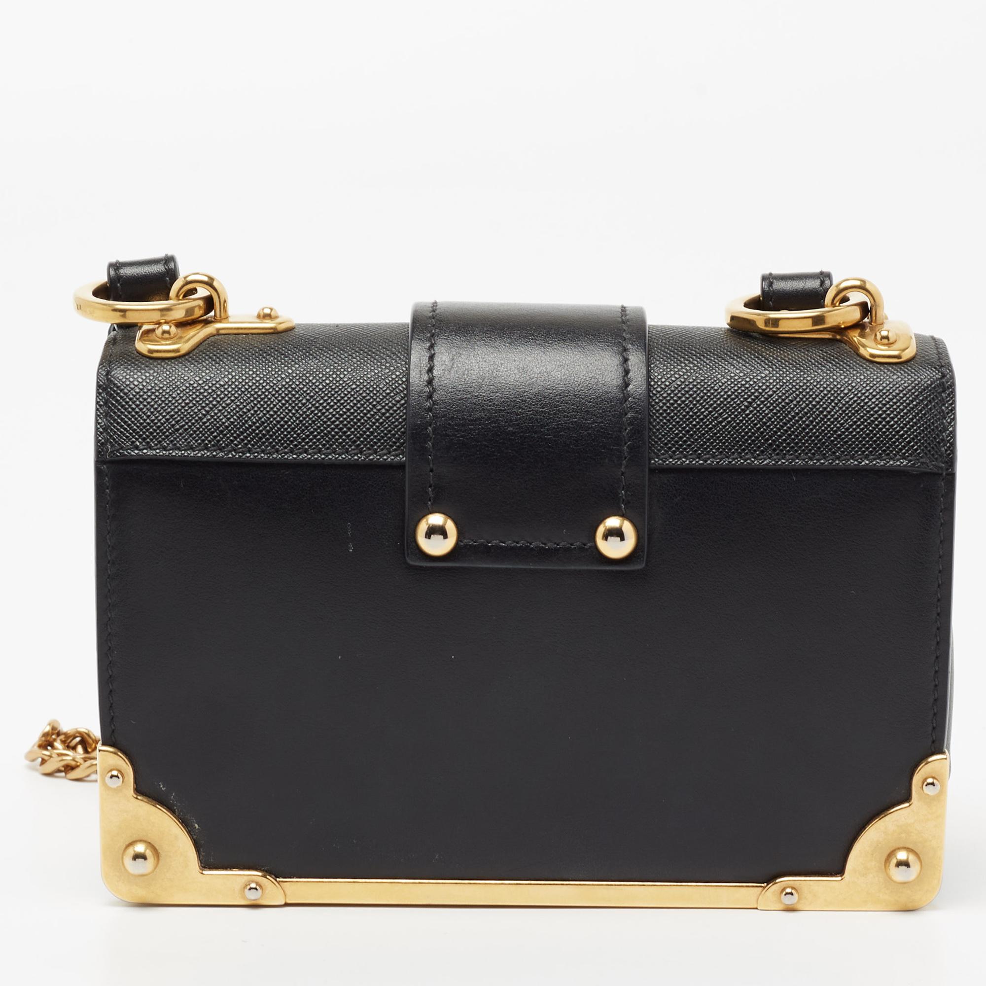 Inspired by valuable books from ancient times, the Cahier by Prada is a best-seller. This bag is crafted using black leather and gold-tone hardware. The flap closure with the brand logo opens to a leather-lined interior with enough space for your