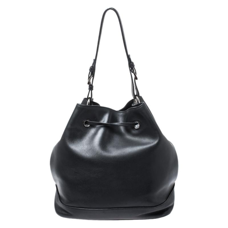 Feel confident and beautiful every time you carry this bucket bag from Prada. Crafted from black leather, this bag offers utmost practicality. It features a single handle, a shoulder strap and a drawstring closure that secures a well-sized