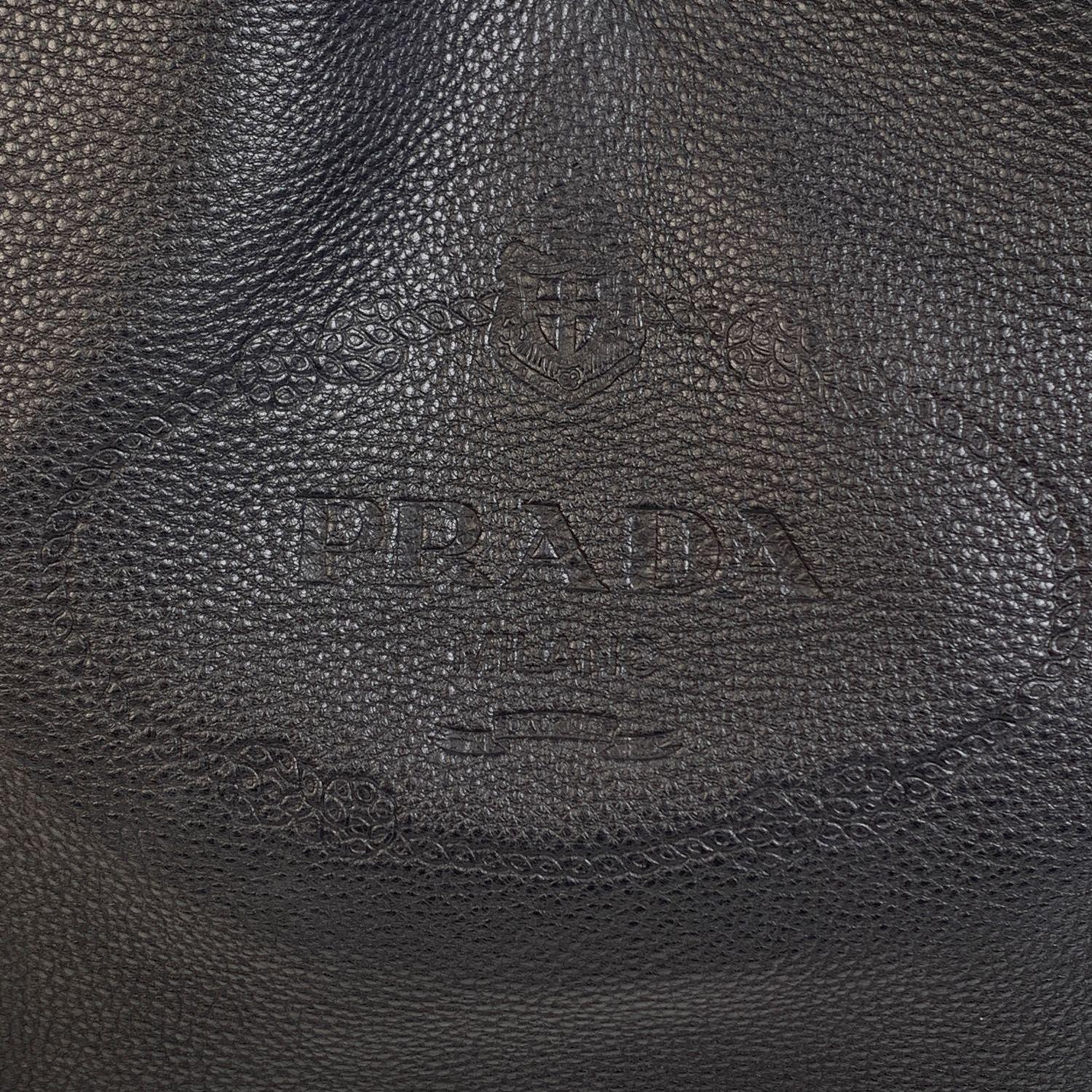 Diese schöne Tasche wird mit einem Echtheitszertifikat von Entrupy, einem führenden internationalen Modeauthentifizierer, geliefert. Die Bescheinigung wird ohne weitere Kosten ausgestellt.

Prada schwarz Vitello Leder Hobo Tote Bag, mod. 1BC051.