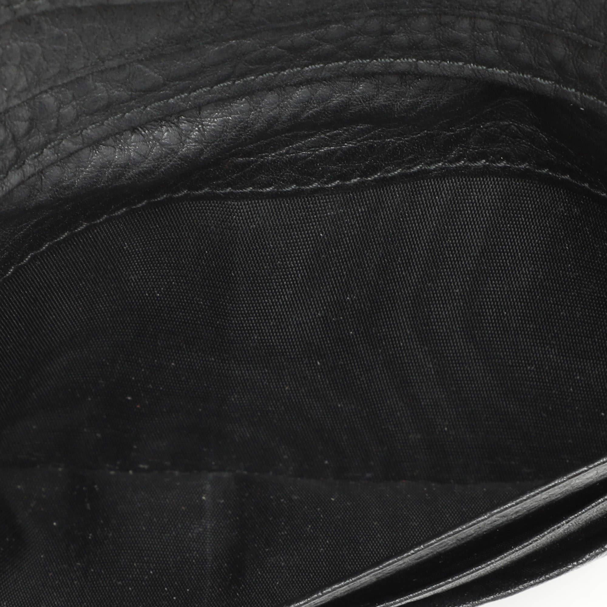 Prada continues its history of delivering finely crafted accessories with this wallet. It has been crafted from black leather and shaped beautifully. The clutch like wallet has a flap with logo detailing and it secures the lined interior.