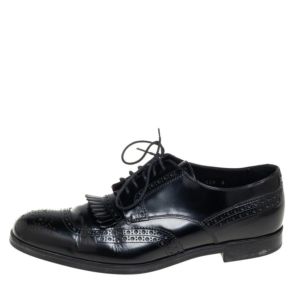 In a grand blend of luxury and practical style comes this pair of derby shoes from Prada. The designer shoes are covered in black leather and designed with laces and fringe detailing on the vamps. They are elevated on low heels.

