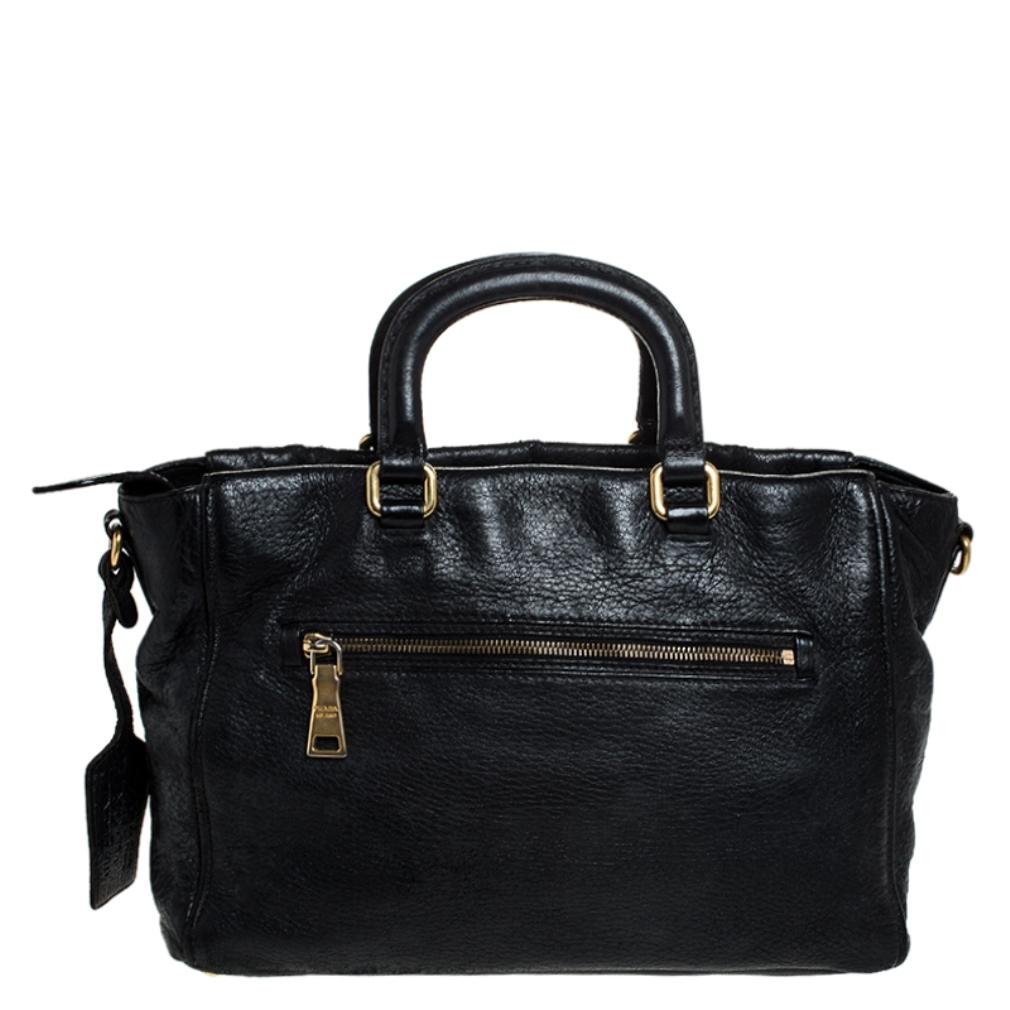 Add some magic to your everyday attire with this super stylish and classy handbag by Prada. Crafted from quality leather, it comes in a stunning shade of black. It comes with dual handles, a detachable strap, an exterior zip pocket with a push-lock