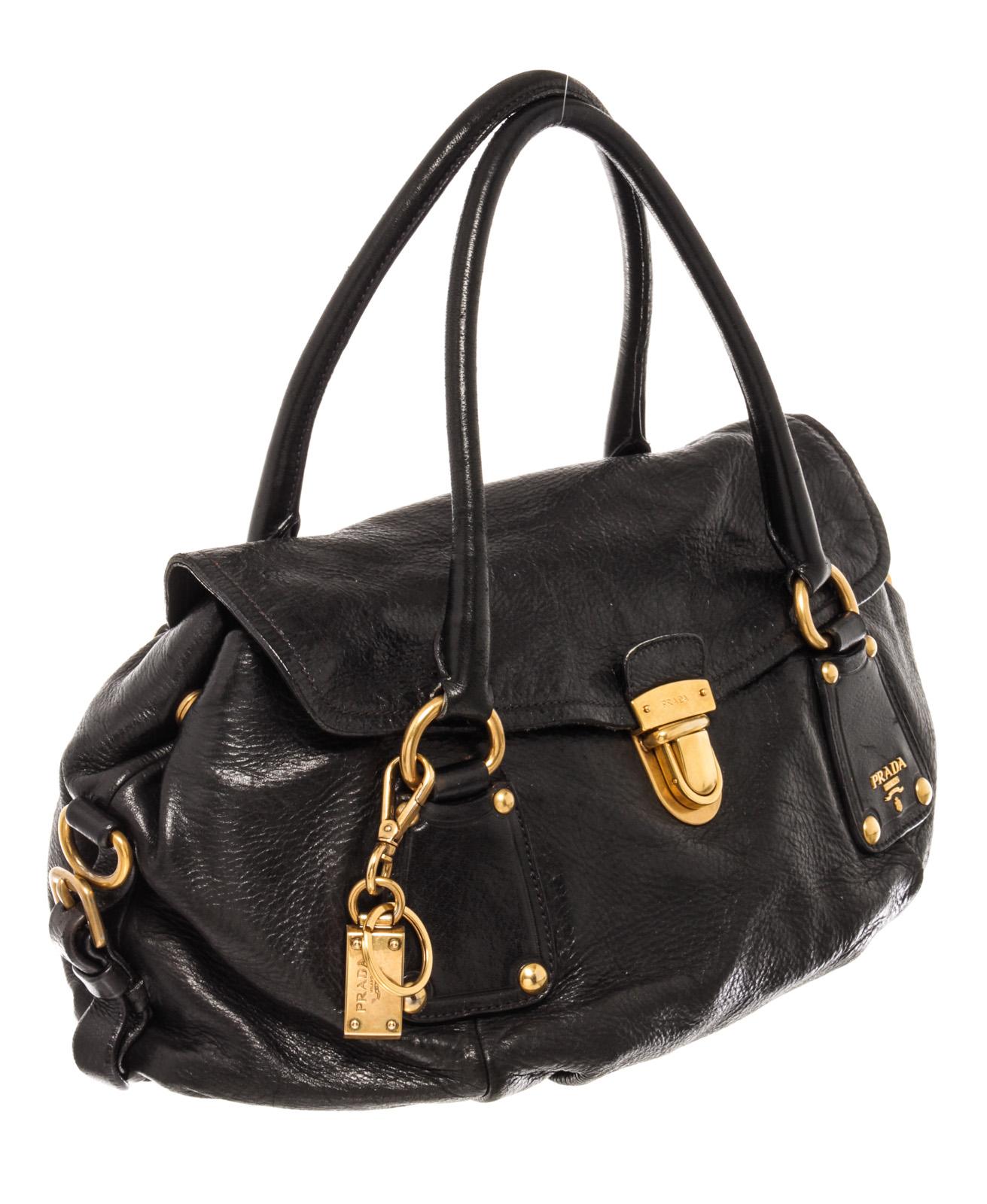 Prada Push-Lock 2way Bag has gorgeous black calfskin leather with and a gold-tone pushlock closure. It features detachable shoulder leather strap, double rolled leather handles and black Prada signature fabric interior lining with one stud-closure