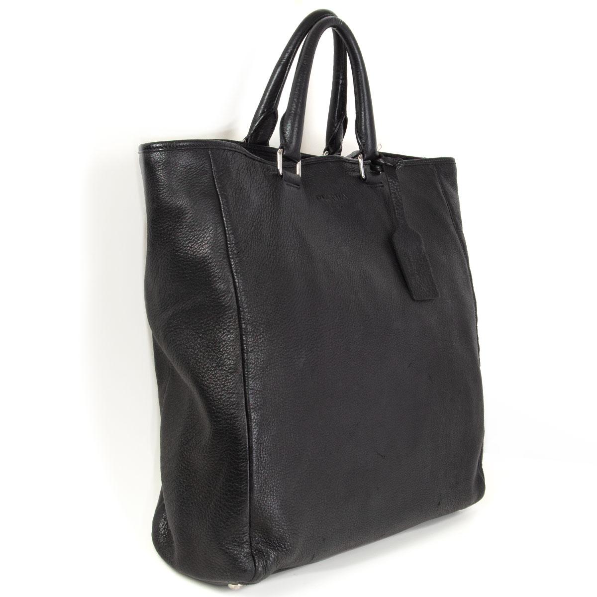Prada large tote in black grained deerskin. Opens wth a push button and is lined in black nylon with one zipper pocket against the back and one big open pocket against the front. Has been carried with natural patina allover and some wear to the
