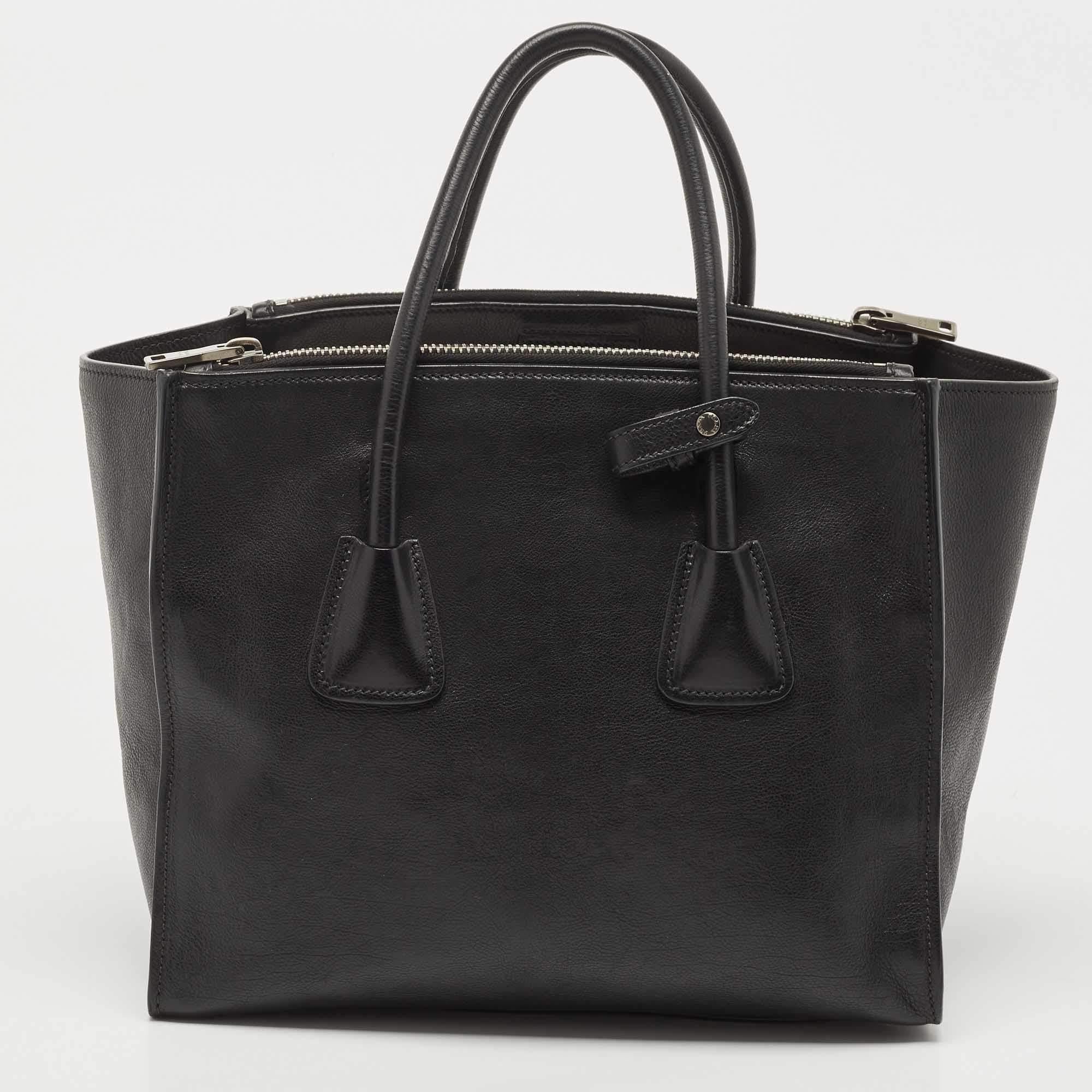 Add timeless style and luxury to your everyday looks with this stunning Prada tote. Crafted in black leather, this bag can store all that you need in its interior. The bag is equipped with the brand logo on the front and dual handles.

Includes: