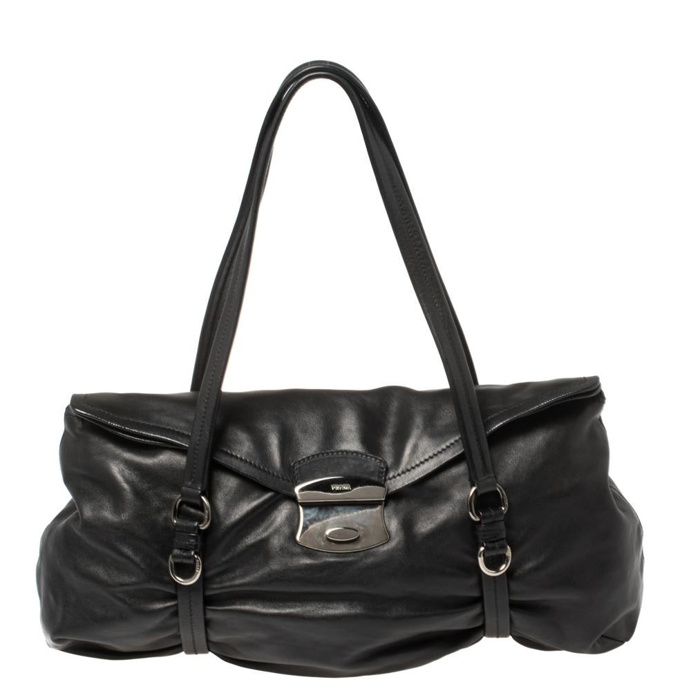 This lovely bag by Prada carries an elegant design. It will be a luxe addition to anything you wear it with. It features a push lock at the front, a leather exterior, twin handles, and a nylon-lined interior. Grab this striking piece now!


