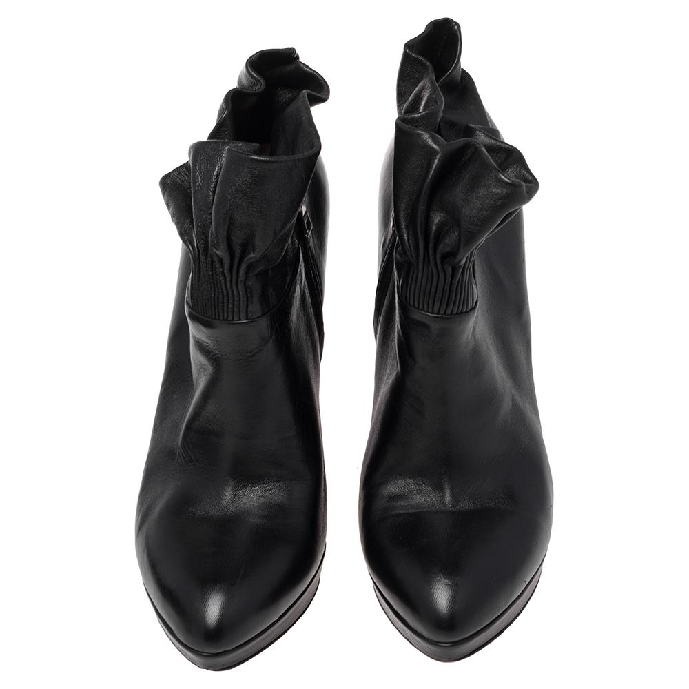 Simple yet classy, this pair of booties from the house of Prada is a class apart. The shoes are designed from premium quality leather, in a black shade. Detailed with sleek heels and an ankle-rise silhouette accented with ruffles, these booties