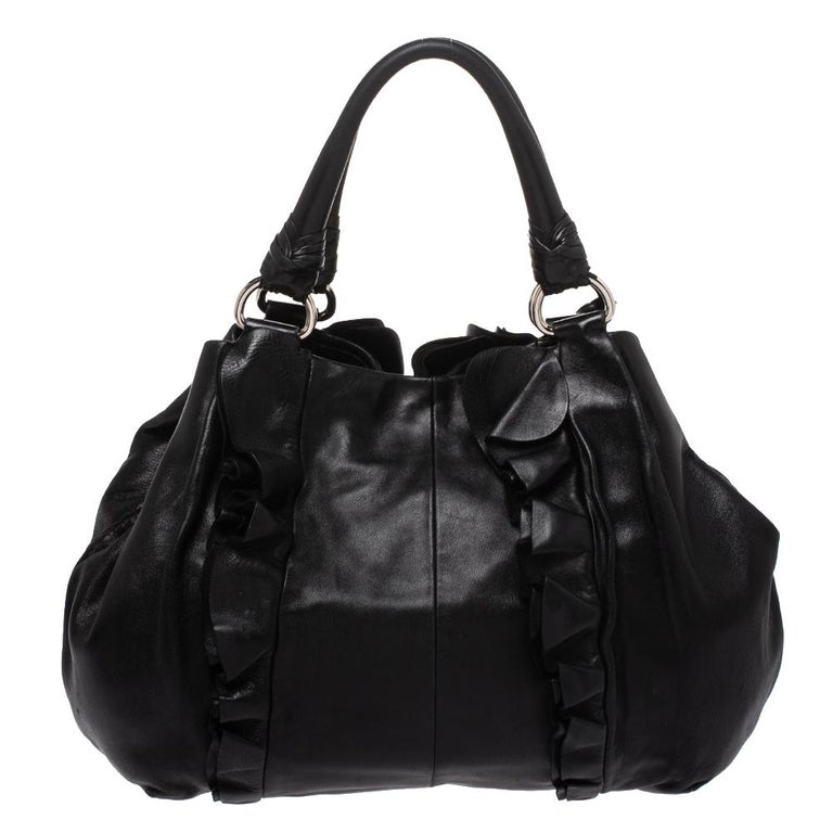 Prada never fails to impress and this Mordore hobo aptly justifies that. This black hobo is crafted from leather and features a chic silhouette. It flaunts a ruffle and stripe detailing all over and comes equipped with dual top handles with an
