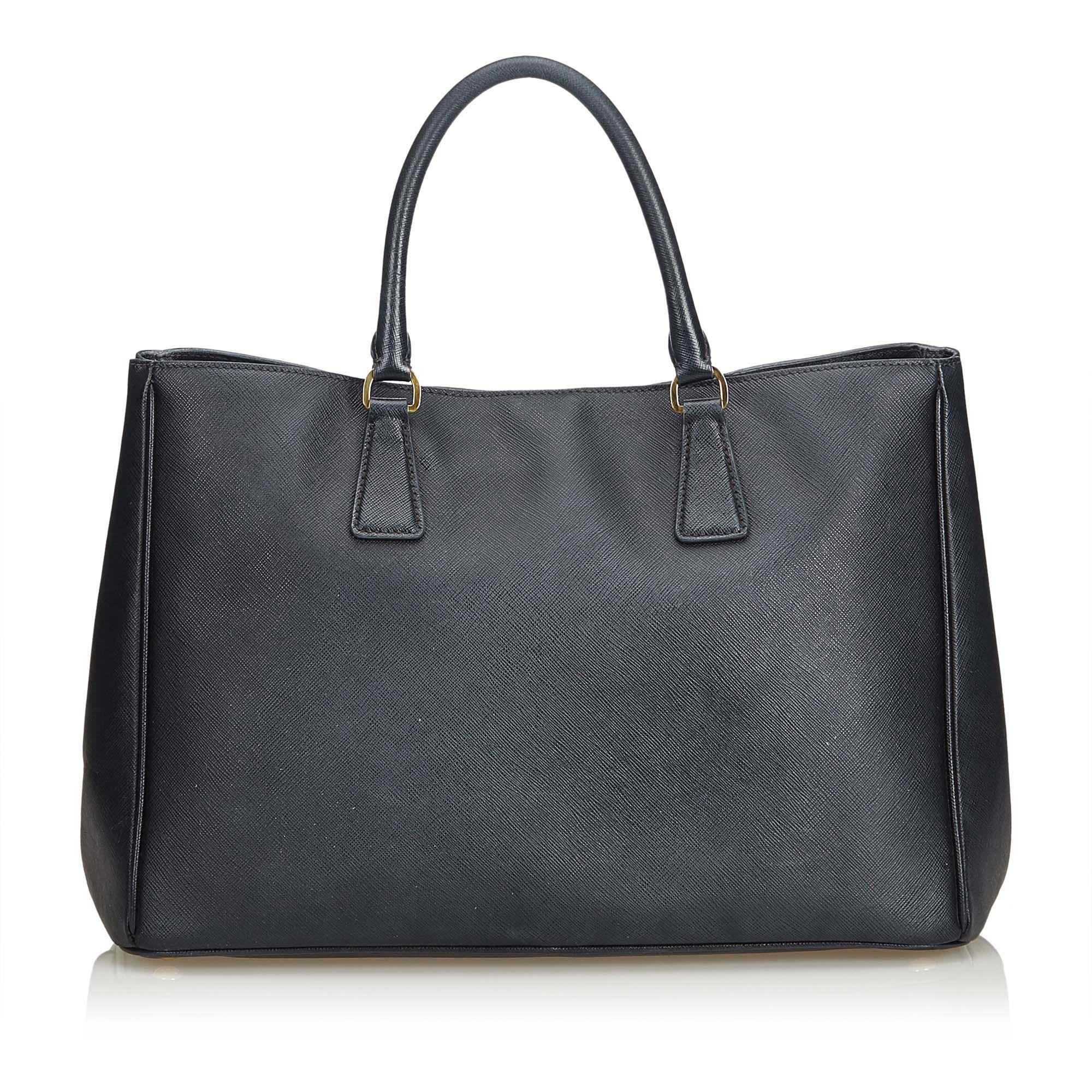 The Galleria handbag features a saffiano leather body, rolled handles, an open top with a magnetic snap button closure and interior zip and slip pockets. It carries as B+ condition rating.

Inclusions: 
Authenticity Card

Dimensions:
Length: 27.00