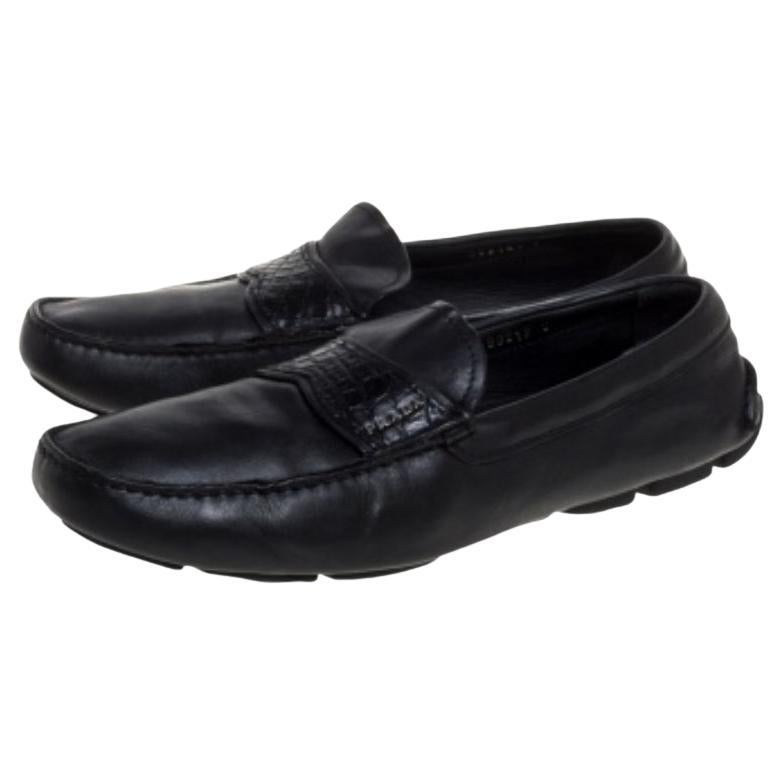 Add value to your ensemble by slipping into this pair of loafers from Prada. Made from black leather, they feature an embossed leather strap on the uppers, accented with silver-tone logo detail. Soft and plush, these shoes are sure to bring you