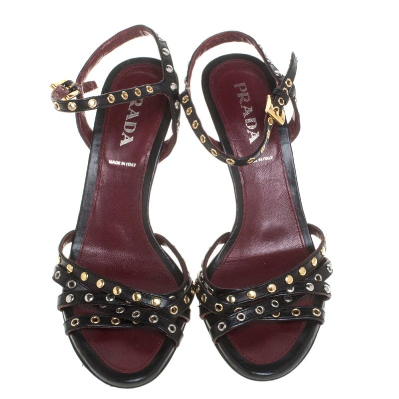 Gehen Sie stilvoll aus mit dieser Kreation von Prada. Diese Sandalen sind aus schwarzem Leder gefertigt und mit Nietenverzierungen versehen. Dieses Paar Sandalen mit offener Spitze ist mit ledergefütterten Innensohlen, hohen Absätzen und