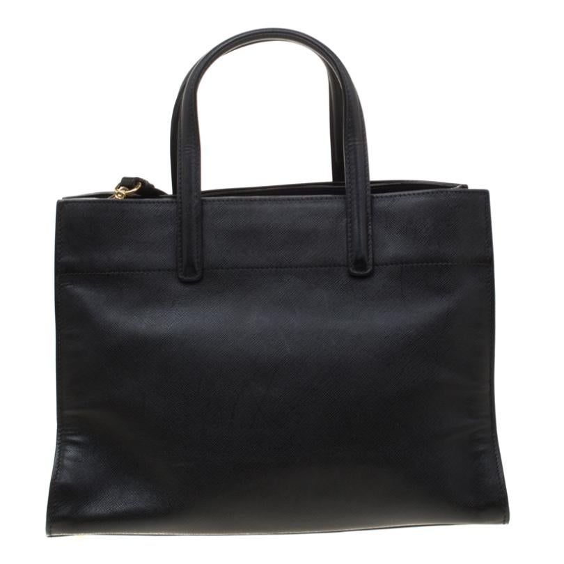 This creation from Prada is crafted from leather and is perfect for daily use. The bag features double handles, gold-tone hardware and a removable shoulder strap. The leather and nylon lined interior is spacious enough to fit your daily