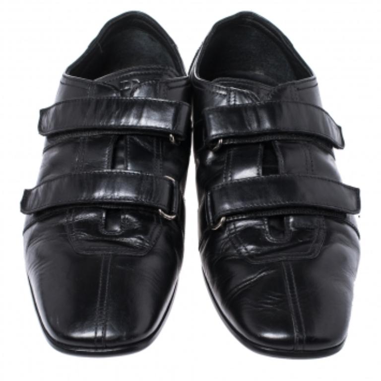 These Prada loafers are perfect for the modern man! Crafted from quality leather in Italy, they come in a versatile shade of black. They are styled with square toes, velcro straps on the uppers, silver-tone hardware, and leather insoles and soles