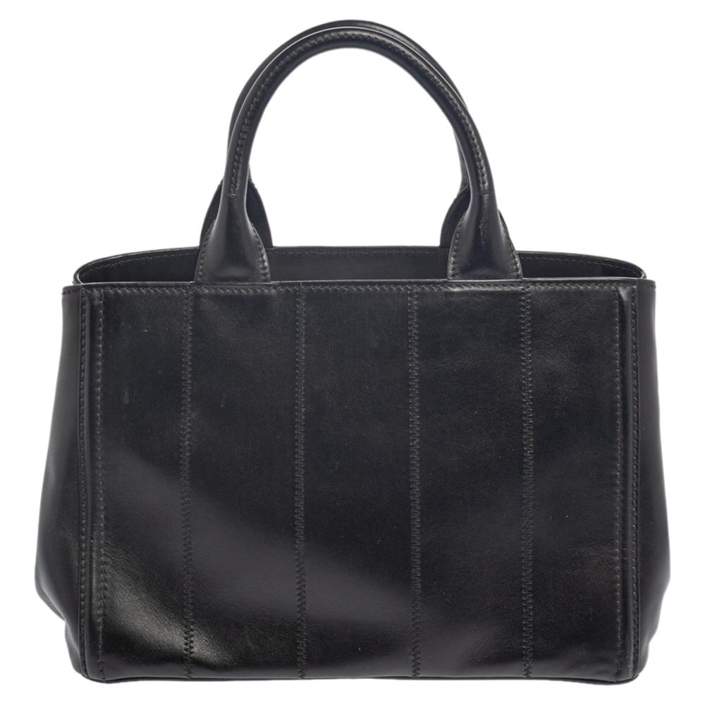 This sleek tote from Prada will surely have your heart instantly. Stand apart with this trendy and beautiful leather tote styled in a stunning black hue with vertical stitch detailing all over the exterior. It is sure to make heads turn. The