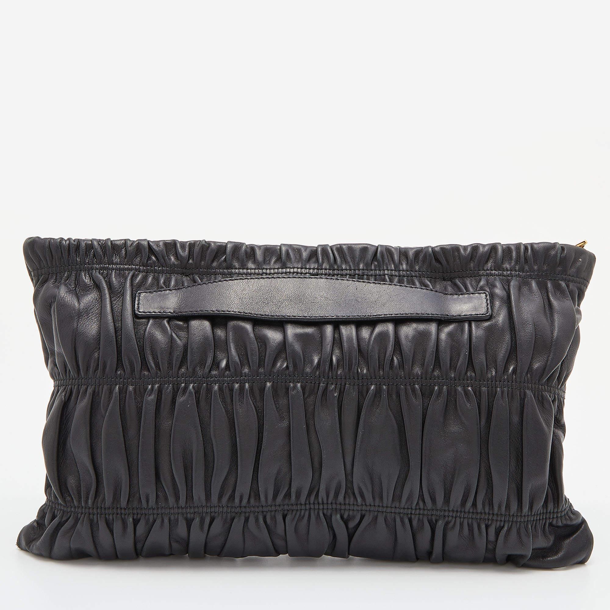 This Prada clutch will instantly please the elegant you. Crafted from black Nappa leather, its signature gauffre-gathered detail is beautifully complemented with gold-tone brand detailing on the front. The nylon-lined interior has ample space to