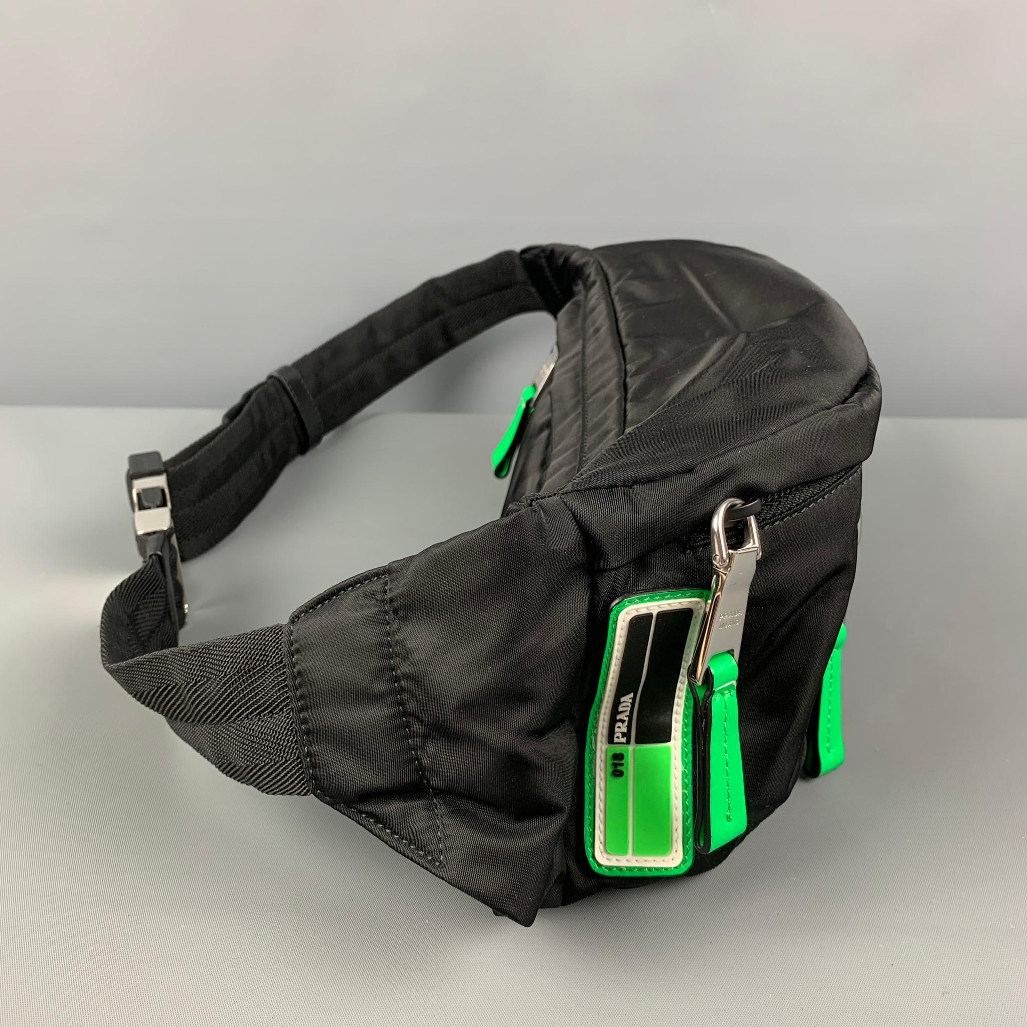PRADA belt-bag comes in black polyester with neon green details featuring a rubber logo detail, front pockets, silver tone hardware, and a adjustable strap closure. Includes dust bag. 

Very Good Pre-Owned Condition.
Marked: