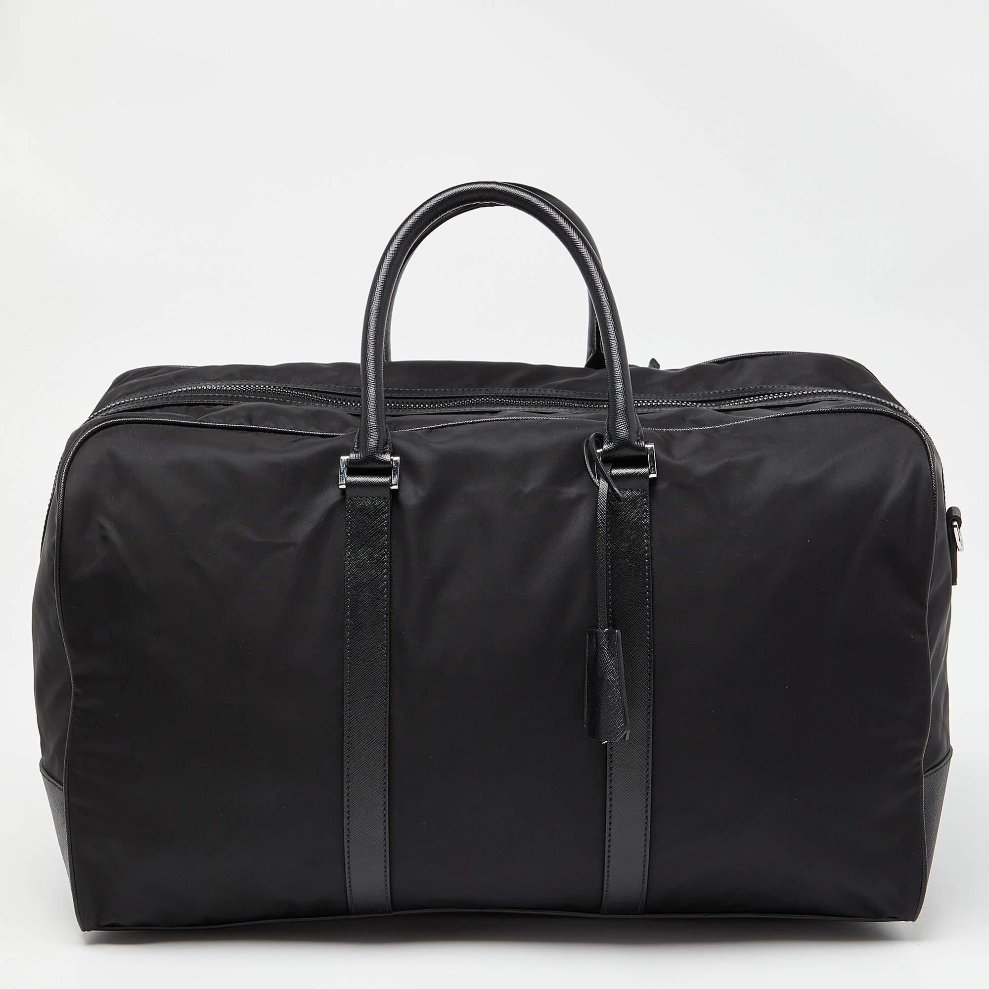 The Prada duffle bag is a sophisticated and versatile accessory. It combines durable black nylon with elegant leather accents. With a spacious interior, multiple pockets, and a detachable shoulder strap, it's perfect for both travel and everyday