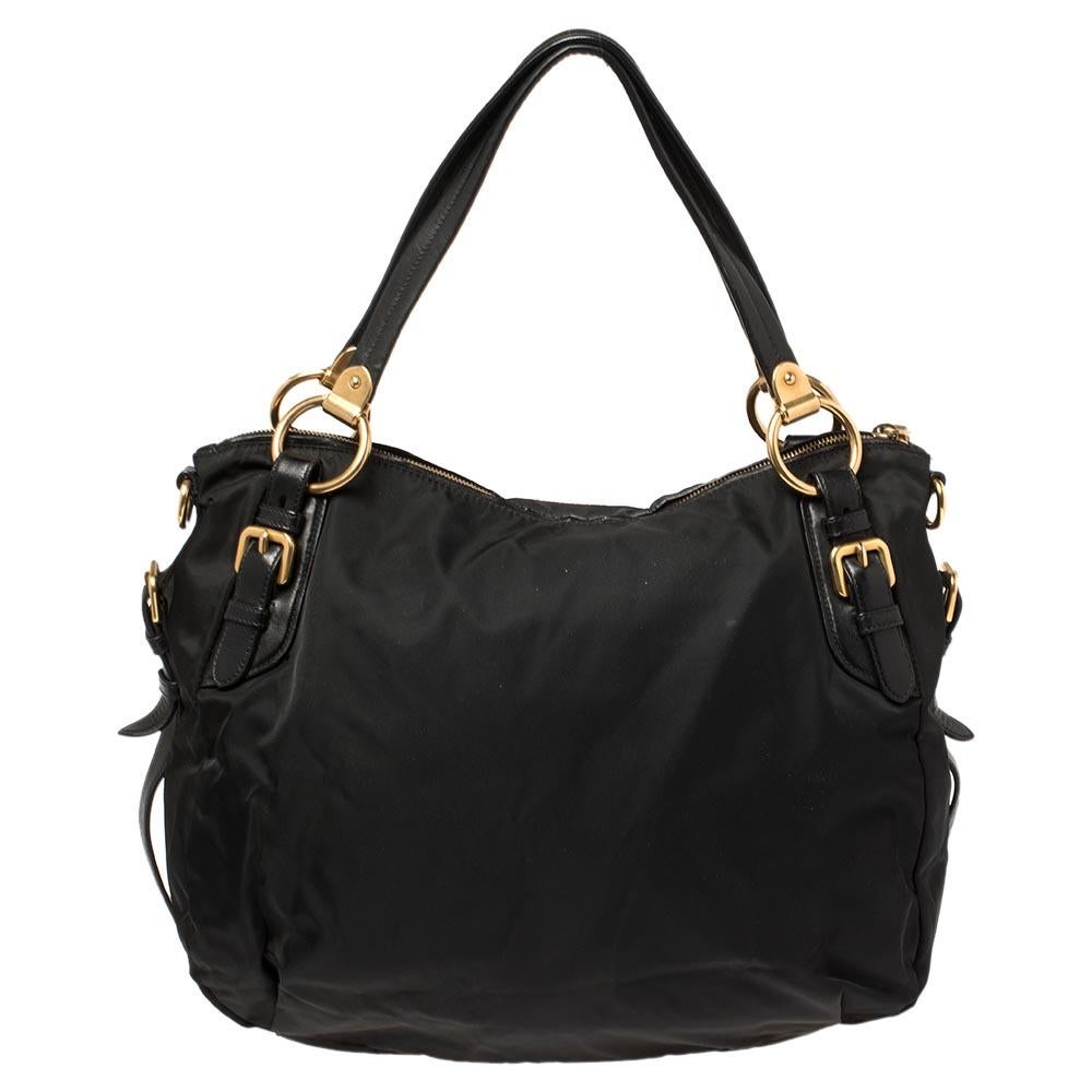 This shoulder bag from Prada is a perfect size to fit all your daily essentials, while the sleek and stylish design will never fail to lend you a look fashionable. Crafted in black nylon, this bag's silhouette is trimmed with leather. The creation