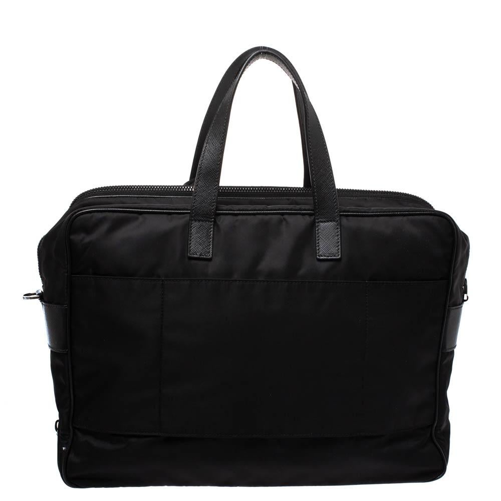 A practical bag for work and meetings this Prada number will be your best companion. This briefcase is crafted from nylon and secured with dual zip closure. It comes fitted with two top handles and a front zip pocket. It opens to a nylon lined