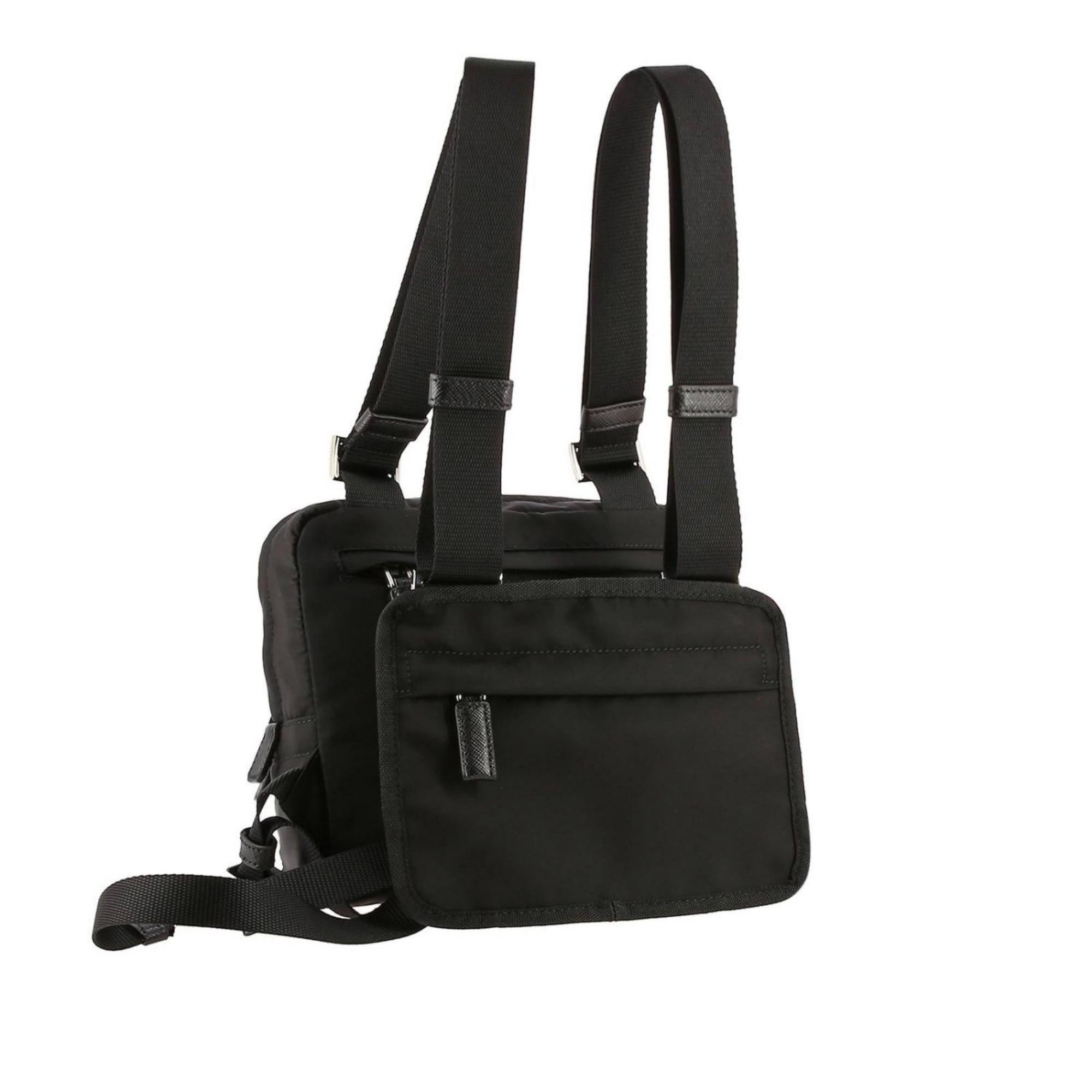 Prada nylon harness bag with saffiano details and adjustable shoulder straps with metallic buckles. It features front zip bag with zip compartment, zip pocket, inside zip pocket and nylon lining. Metal and enamel triangle, back pouch with zip.