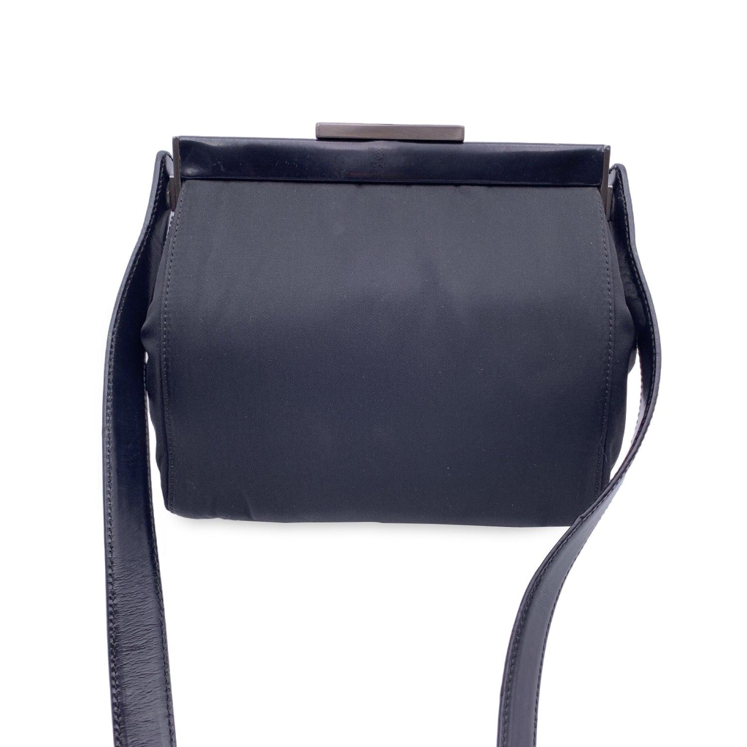 Prada framed nylon bag. . Push lock signature Prada top closure. The bag is crafted of black nylon withPatent leather frame and shoulder strap. Gunmetal hardware. Interior has1 side zip pocket Prada tag inisde. Small label with number inside the