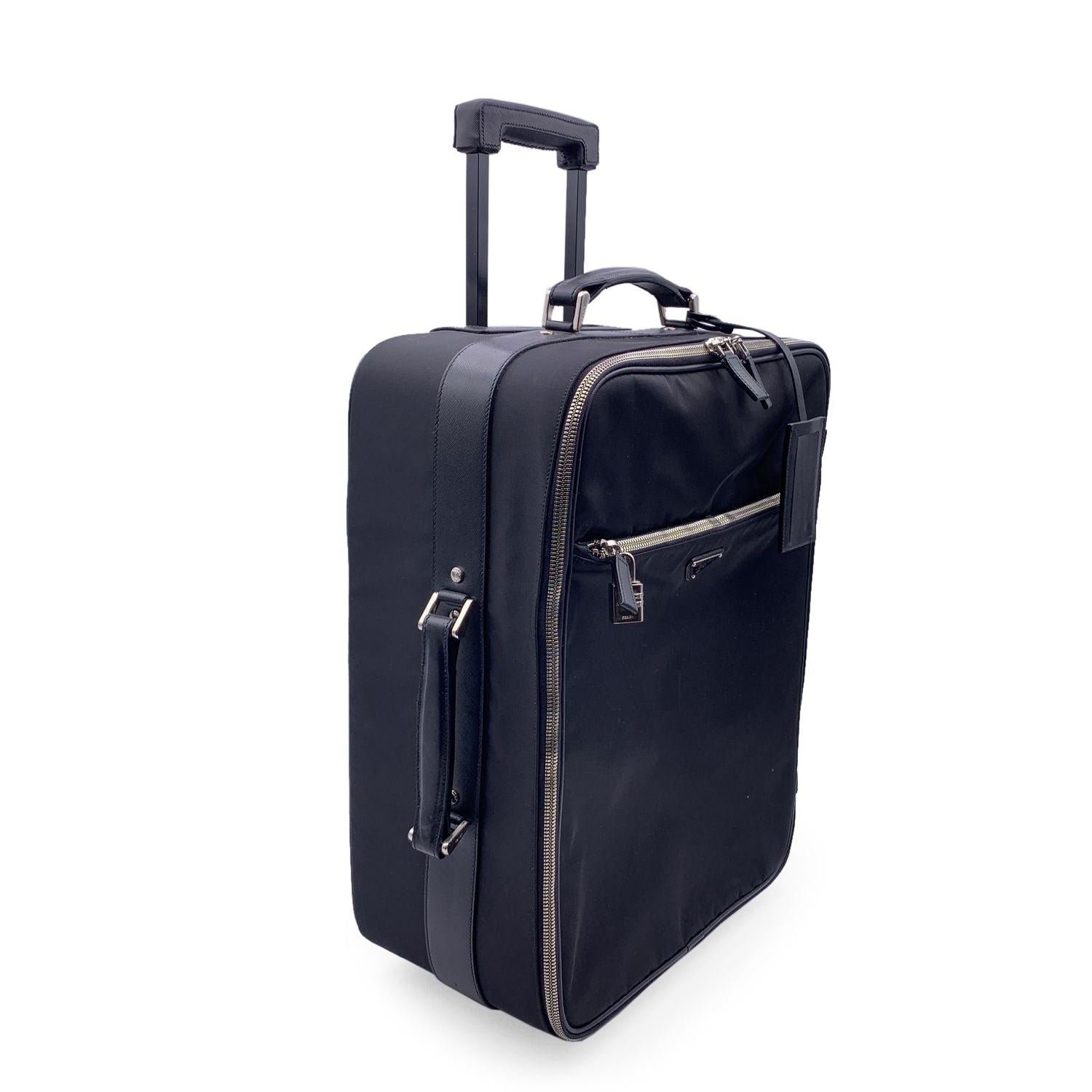 Gorgeous Prada Rolling Luggage Trolley travel bag. Black nylon, saffiano leather trim and fabric lining. Prada triangle logo on the front. Silver metal hardware. Double zipper closure. 1 front zip pocket and 1 rear zip pocket . Top handle and side