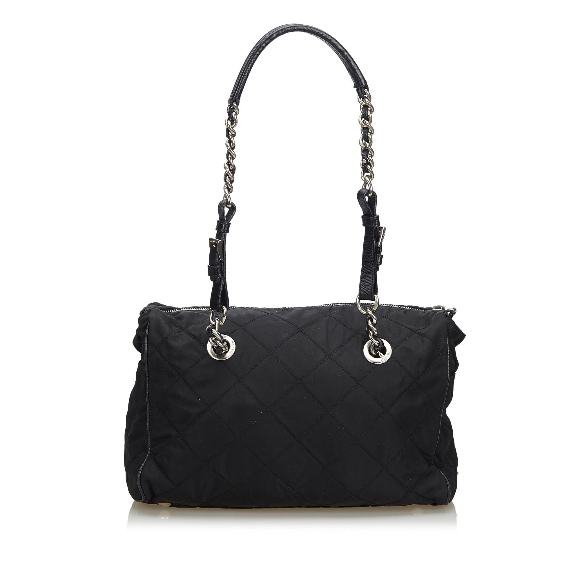 Prada presents an exclusively designed exquisite tote bag for the stylish you. A stylish option for everyday use or special events, this impressive black tote is true to its existence. This attractive piece crafted with fabric, nylon and leather