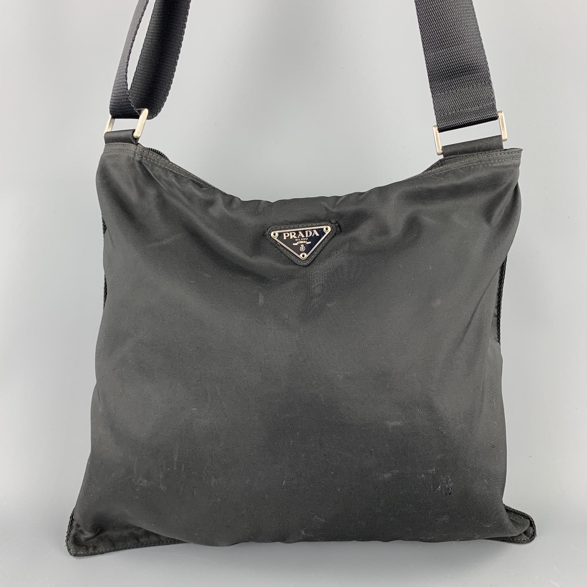PRADA handbag comes in a black nylon featuring silver tone hardware, crossbody strap, and a zip up closure. Wear throughout. As-Is. Made in Italy.

Fair Pre-Owned Condition.
Marked: 25

Measurements:

Length: 12 in.
Width: 2 in. 
Height: 11.5